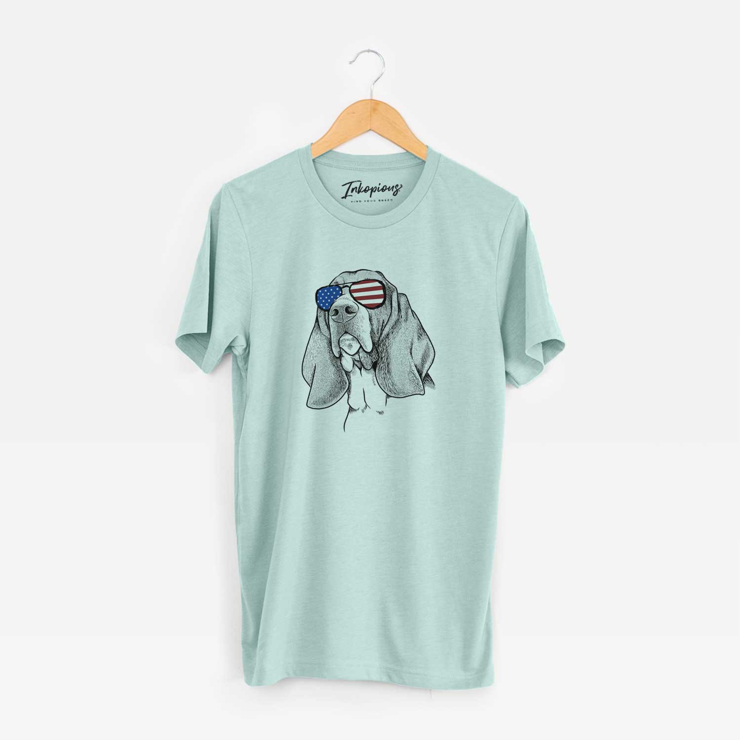 Hand-drawn sketch of Cooper the Basset Hound wearing American flag sunglasses on a Heather Sage Unisex crewneck