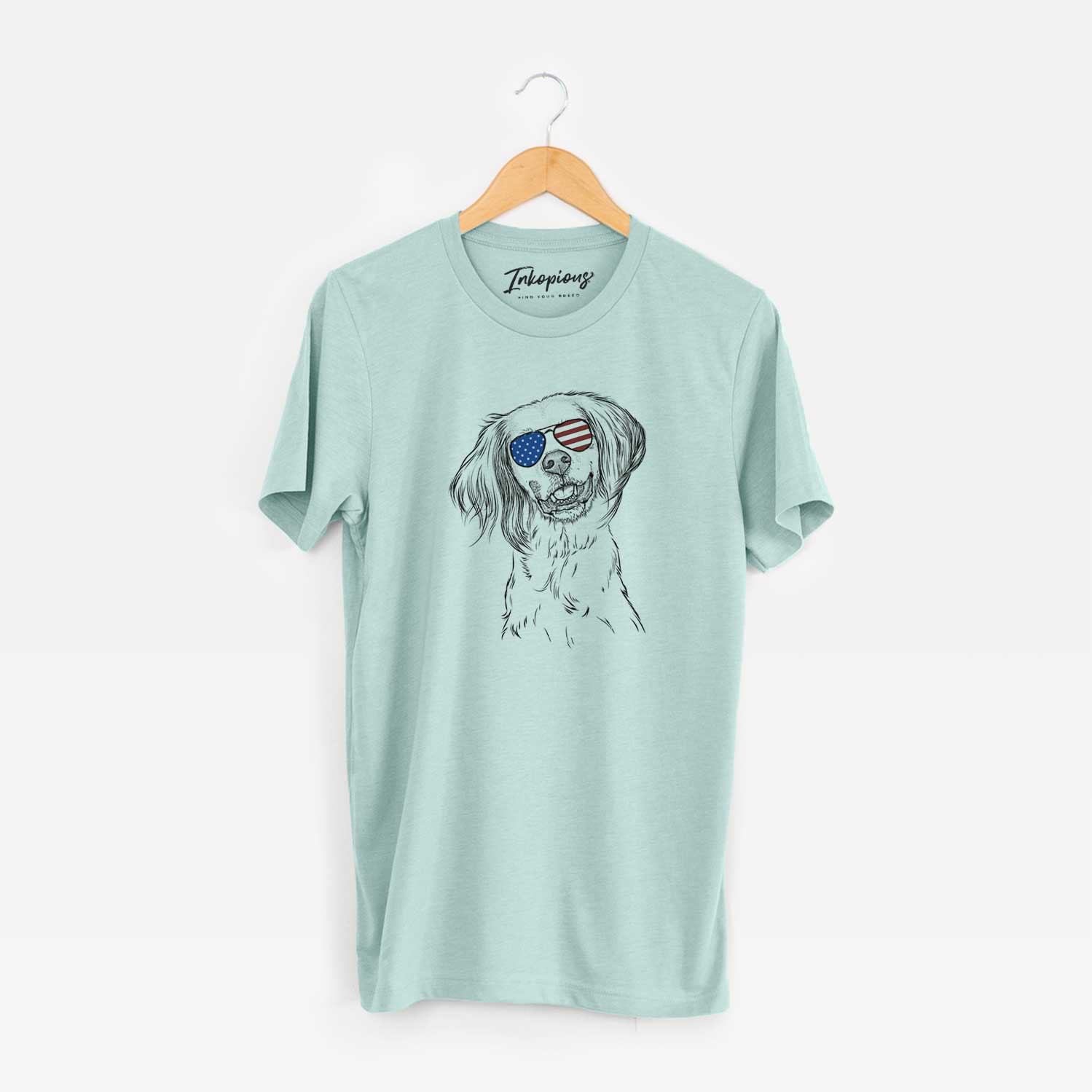 Hand-drawn sketch of Cooper the English Setter wearing American flag sunglasses on a Heather Sage Unisex crewneck