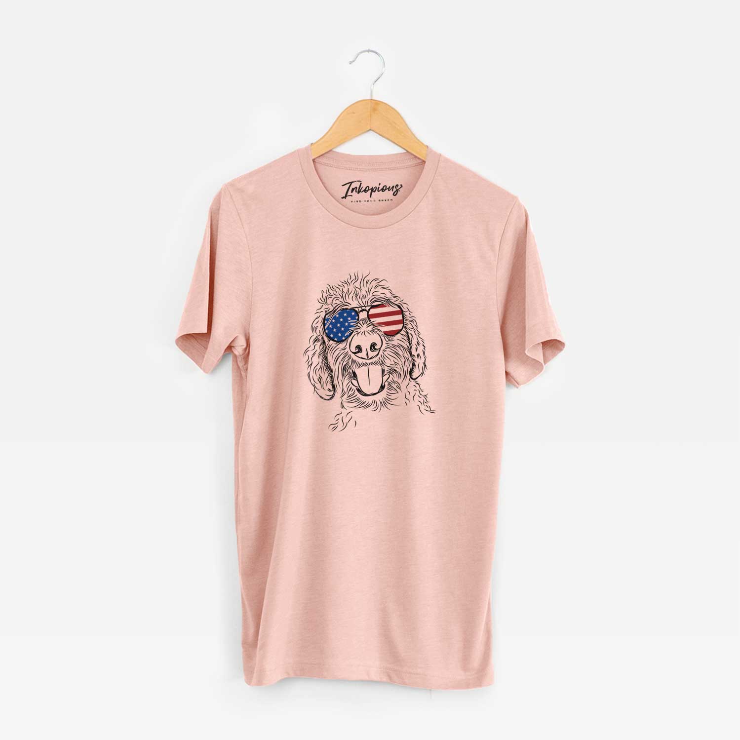 Hand-drawn sketch of Dixie the Doodle wearing American flag sunglasses on a Peach Unisex crewneck