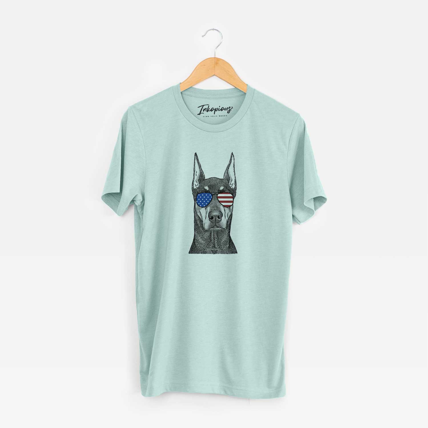Hand-drawn sketch of Drake the Doberman Pinscher wearing American flag sunglasses on a Heather Sage Unisex crewneck