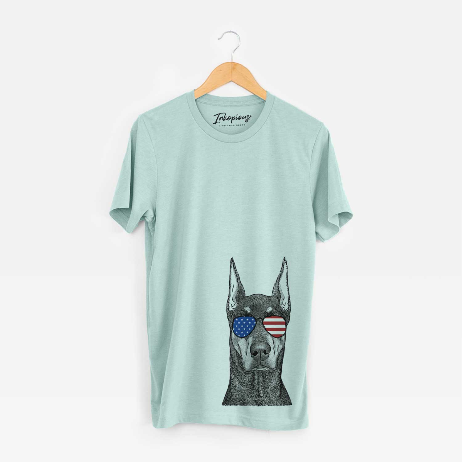Hand-drawn sketch of Drake the Doberman Pinscher wearing American flag sunglasses on a Heather Sage Unisex crewneck