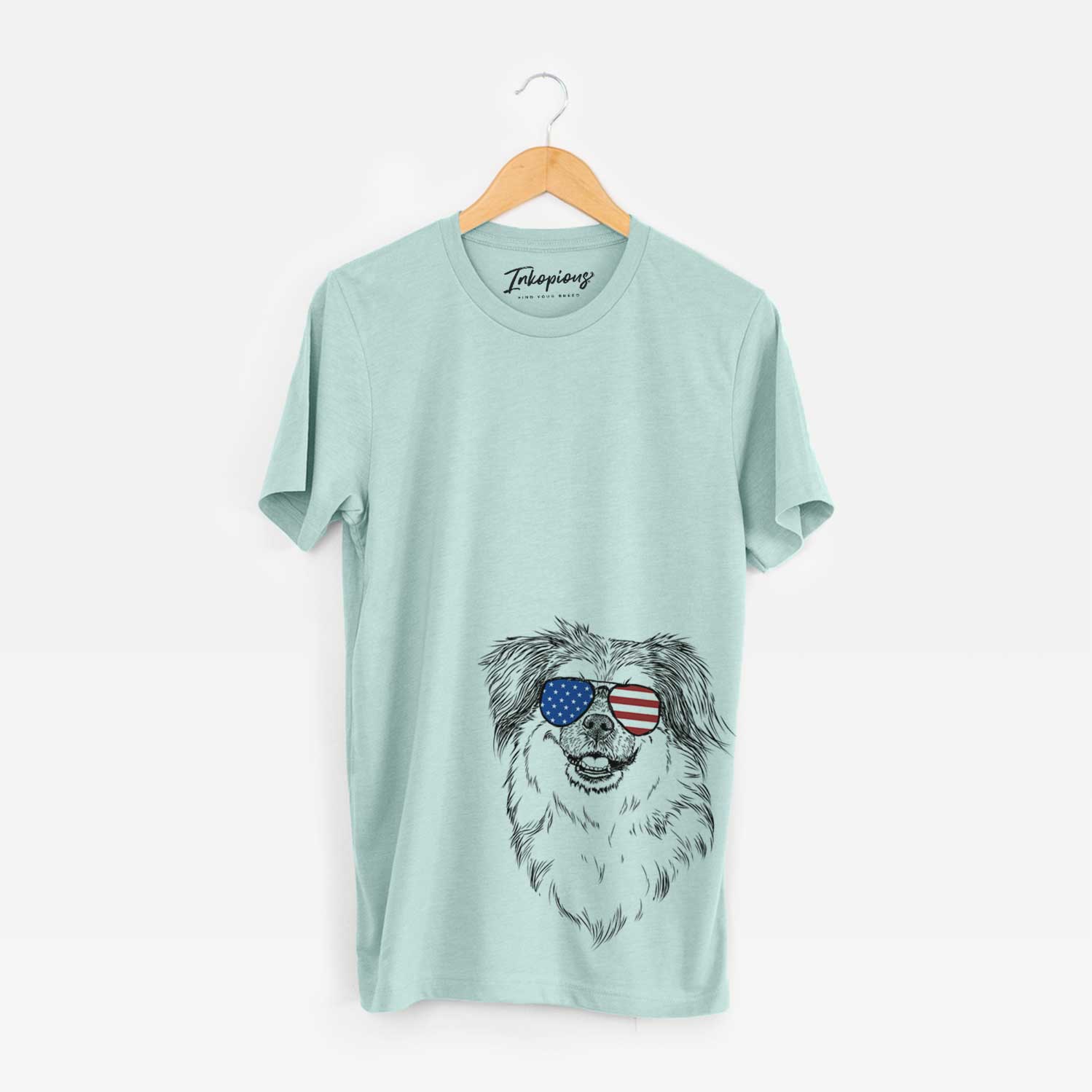 Hand-drawn sketch of Ed the Tibetan Spaniel wearing American flag sunglasses on a Heather Sage Unisex crewneck