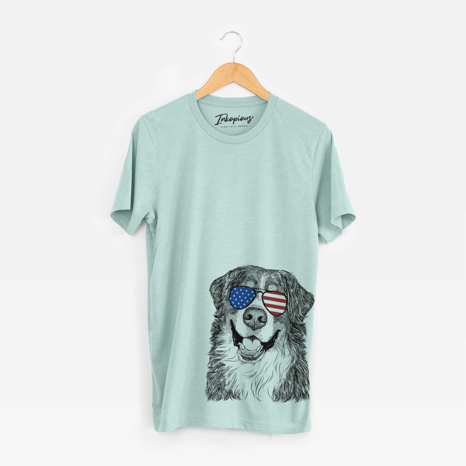 Hand-drawn sketch of Eiger the Bernese Mountain Dog wearing American flag sunglasses on a Heather Sage Unisex crewneck