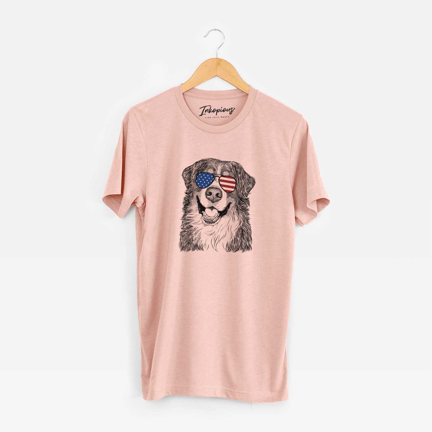 Hand-drawn sketch of Eiger the Bernese Mountain Dog wearing American flag sunglasses on a Peach Unisex crewneck