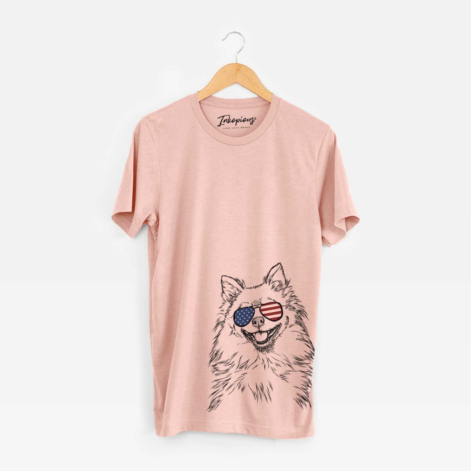 Hand-drawn sketch of Fibi the Spitz wearing American flag sunglasses on a Peach Unisex crewneck