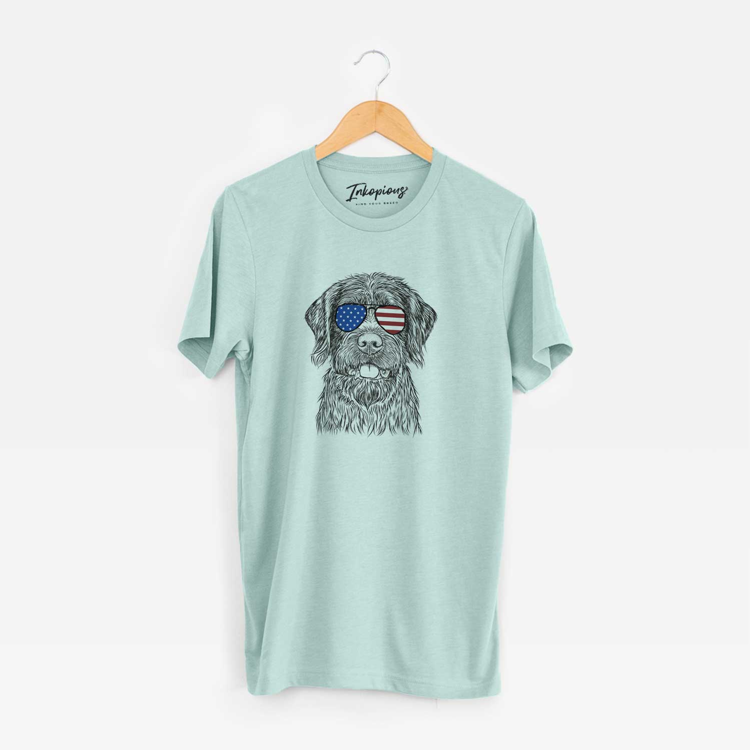 Hand-drawn sketch of Fletcher the Wirehaired Pointing Griffon wearing American flag sunglasses on a Heather Sage Unisex crewneck