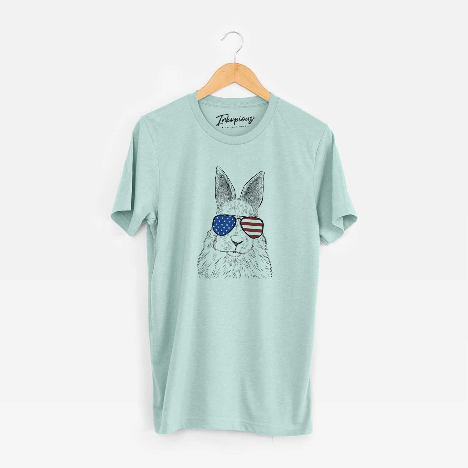 Hand-drawn sketch of Flower the Rex Rabbit wearing American flag sunglasses on a Heather Sage Unisex crewneck