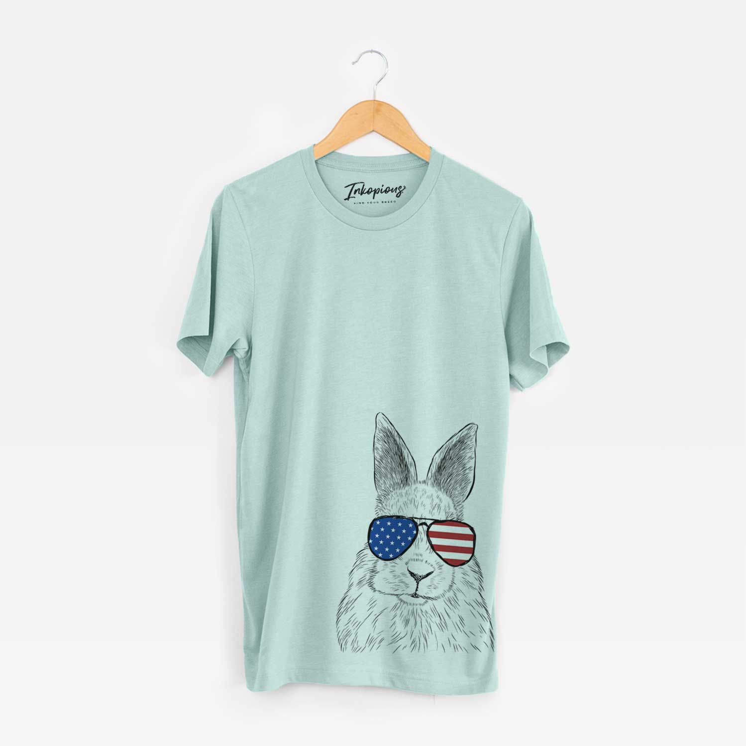 Hand-drawn sketch of Flower the Rex Rabbit wearing American flag sunglasses on a Heather Sage Unisex crewneck
