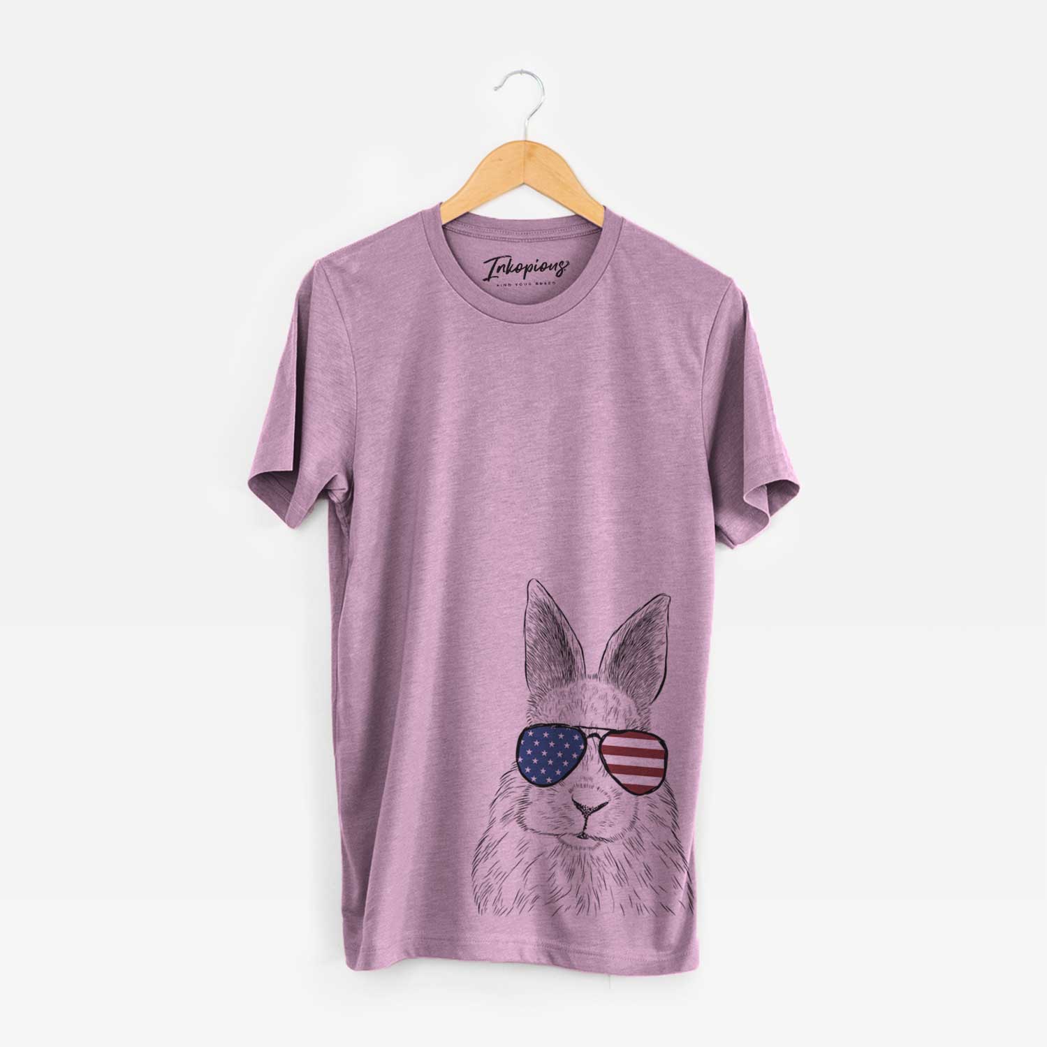 Hand-drawn sketch of Flower the Rex Rabbit wearing American flag sunglasses on an Orchid Unisex crewneck