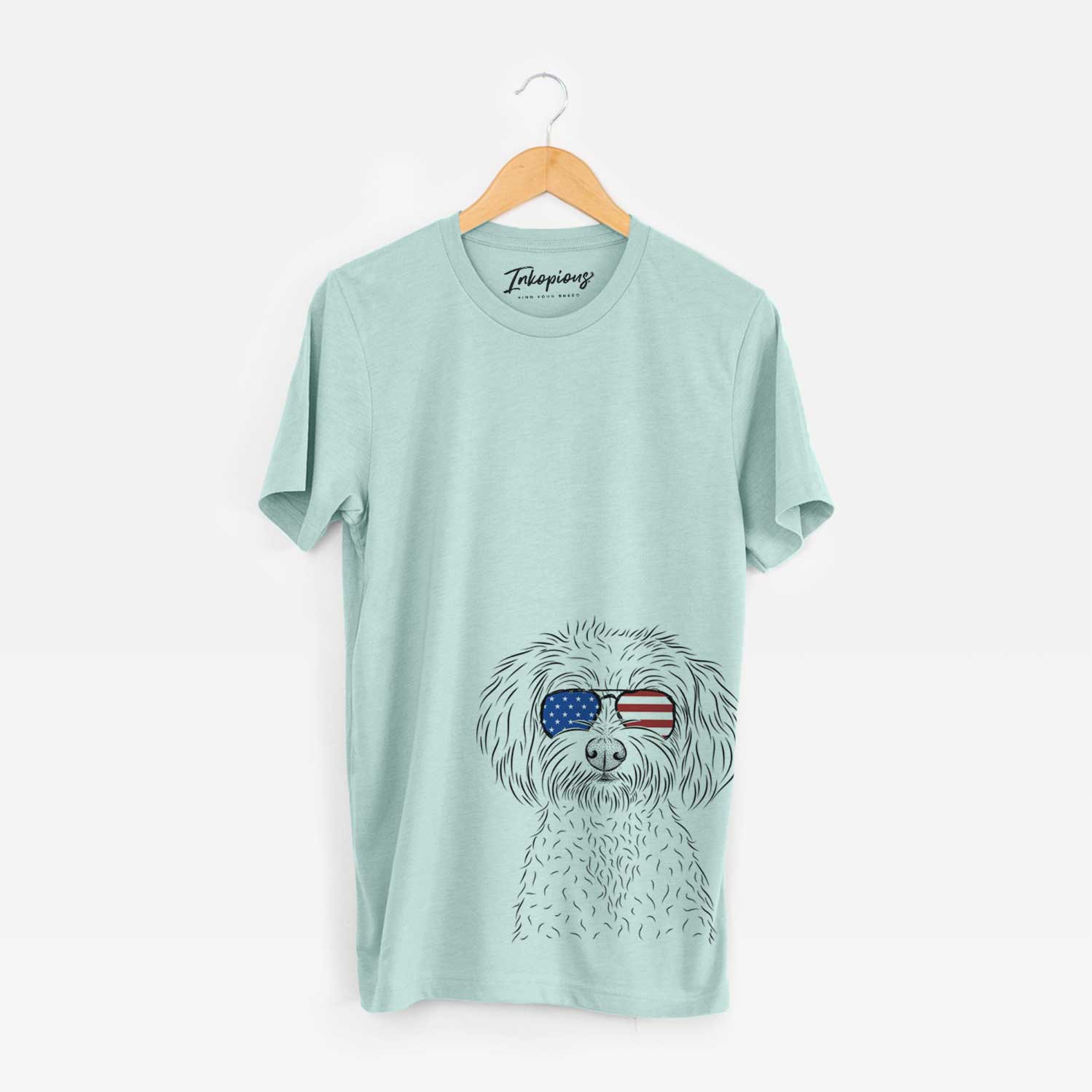 Hand-drawn sketch of Francesca the Maltipoo wearing American flag sunglasses on a Heather Sage Unisex crewneck