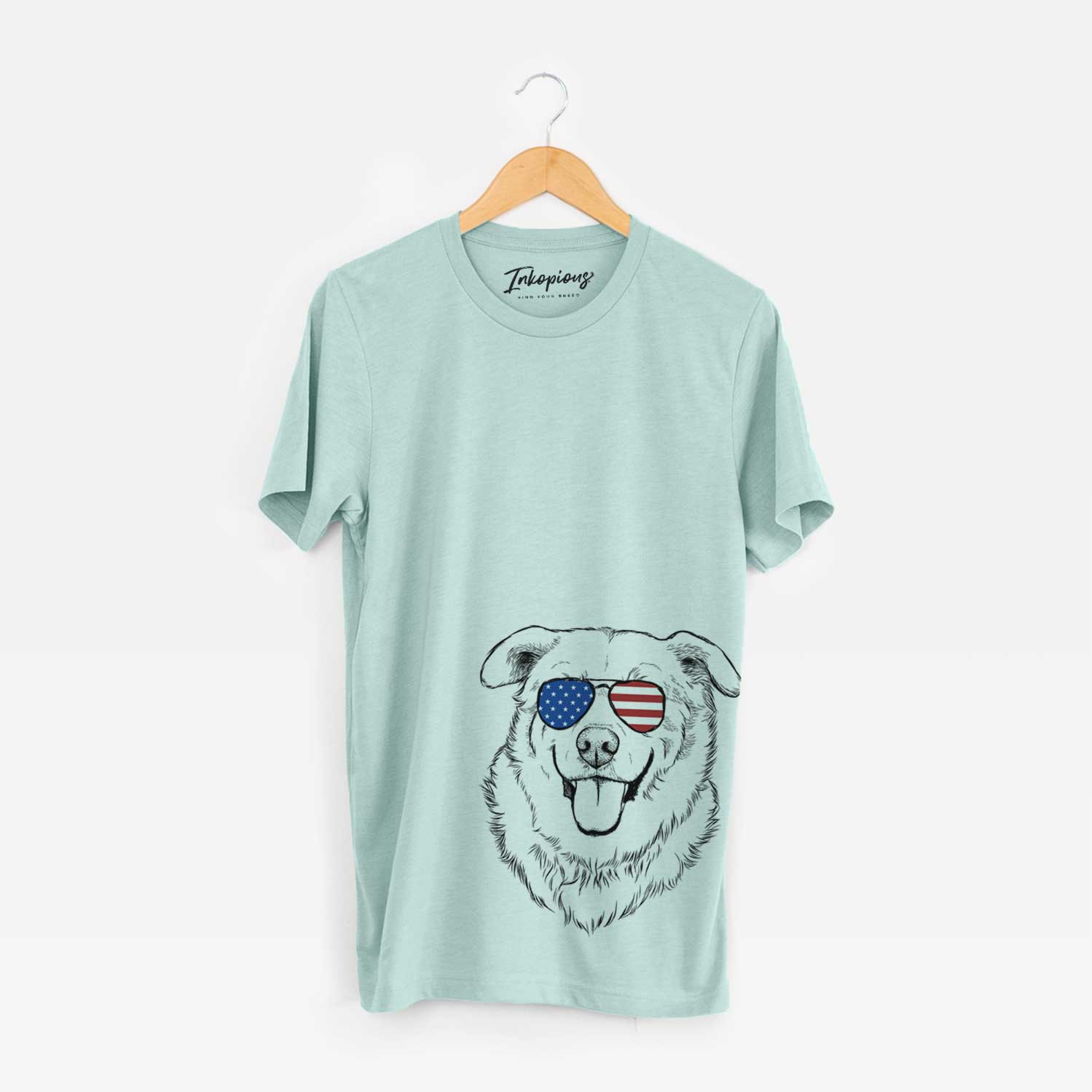 Hand-drawn sketch of Freeley the Mixed Breed wearing American flag sunglasses on a Heather Sage Unisex crewneck