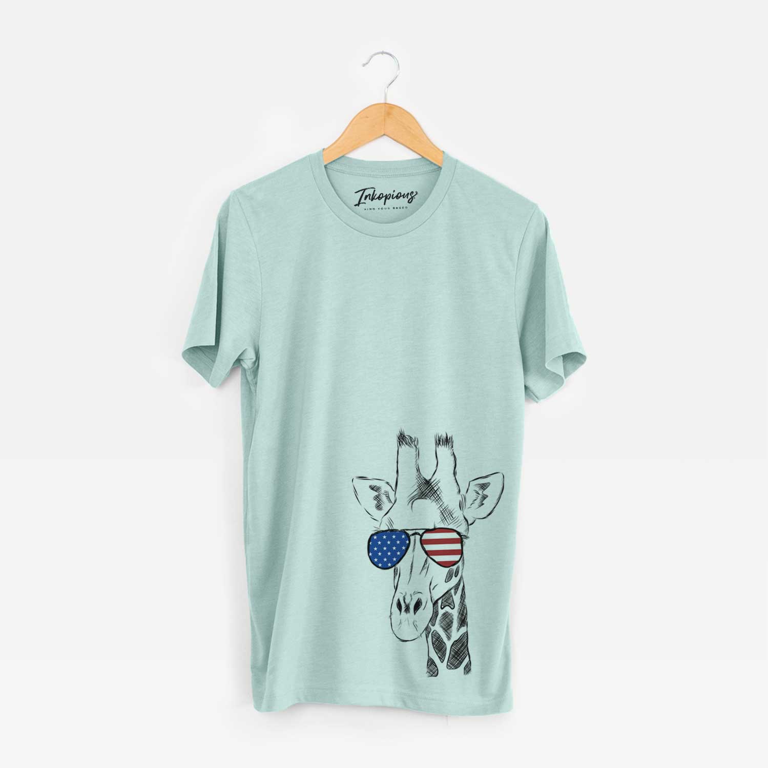 Hand-drawn sketch of Geoffrey the Giraffe wearing American flag sunglasses on a Heather Sage Unisex crewneck