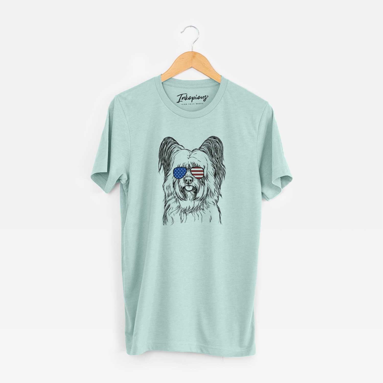 Hand-drawn sketch of Gideon the Skye Terrier wearing American flag sunglasses on a Heather Sage Unisex crewneck
