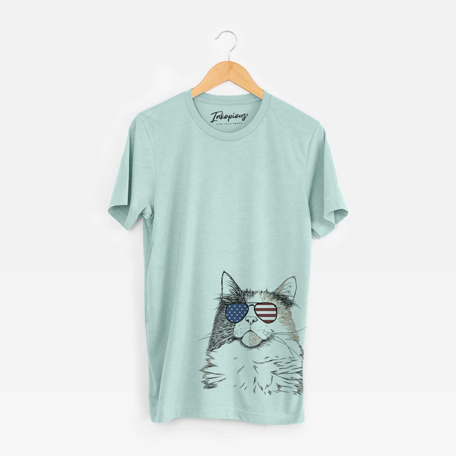 Hand-drawn sketch of Greta the Calico Cat wearing American flag sunglasses on a Heather Sage Unisex crewneck