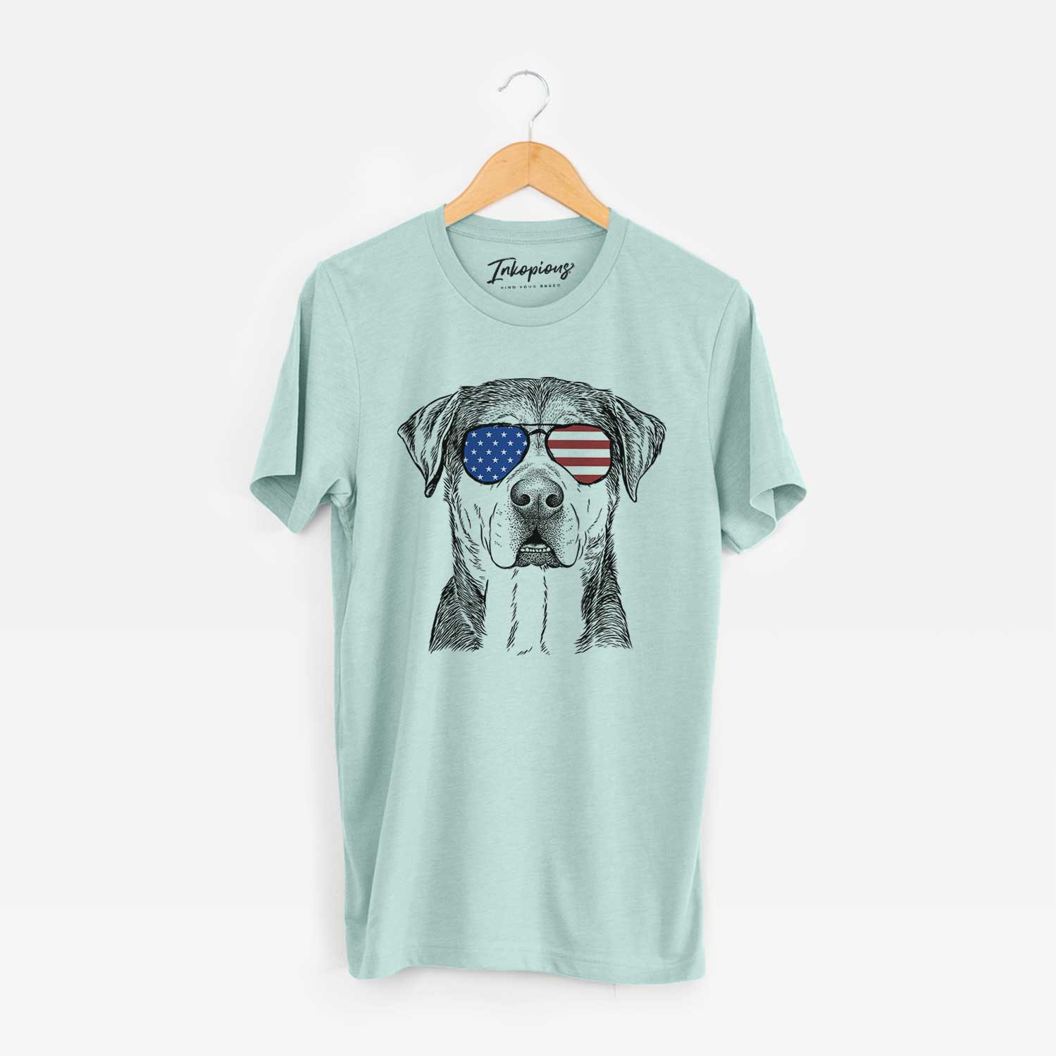 Hand-drawn sketch of Gus the Rottweiler Mix wearing American flag sunglasses on a Heather Sage Unisex crewneck