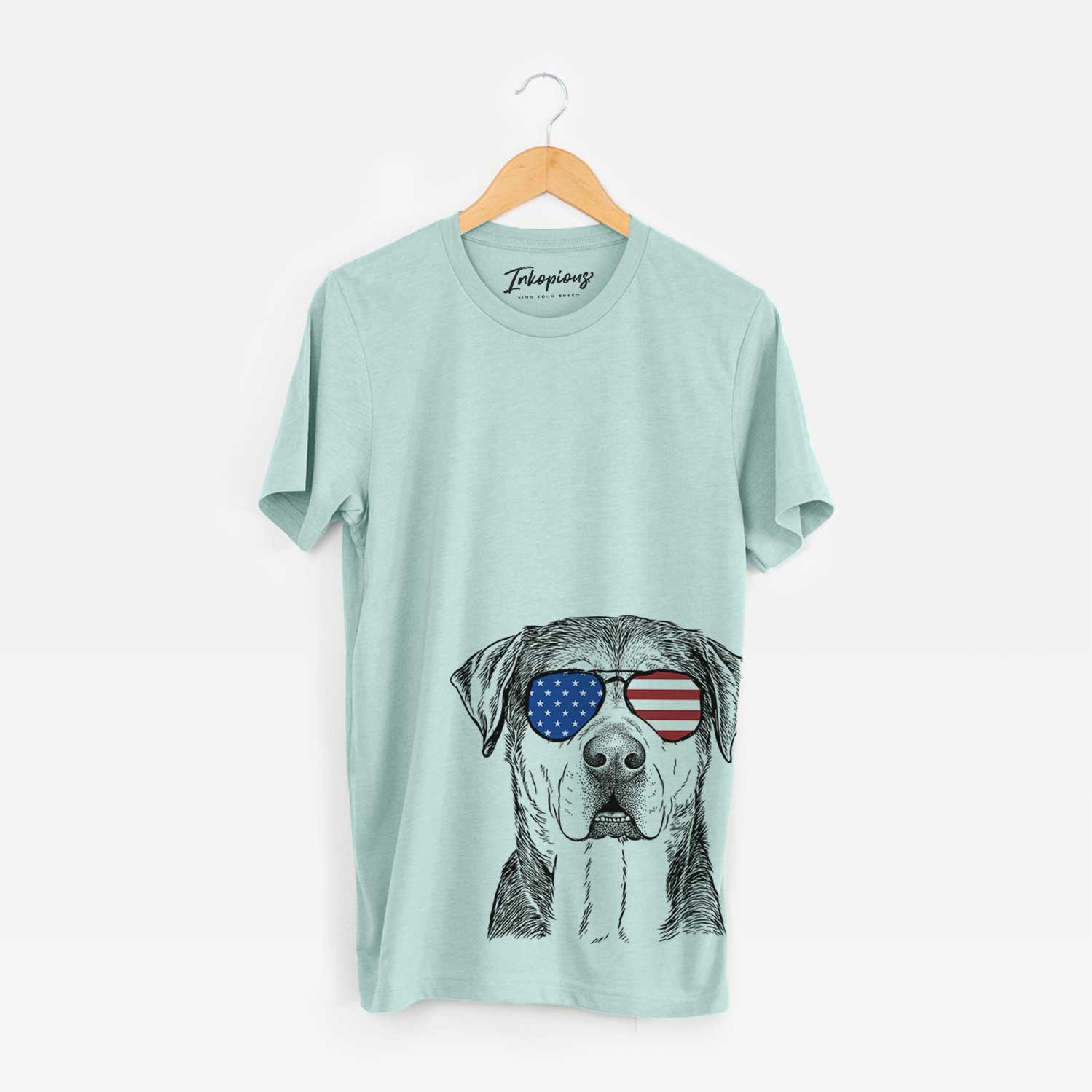 Hand-drawn sketch of Gus the Rottweiler Mix wearing American flag sunglasses on a Heather Sage Unisex crewneck