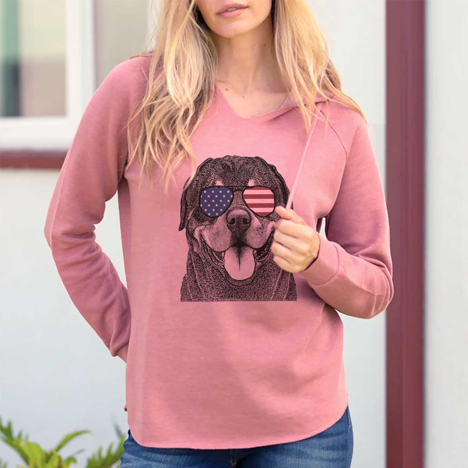 Hand-drawn sketch of Hagan the Rottweiler wearing American flag sunglasses on a Dusty Rose Cali Wave Hooded Sweatshirt, lifestyle photo