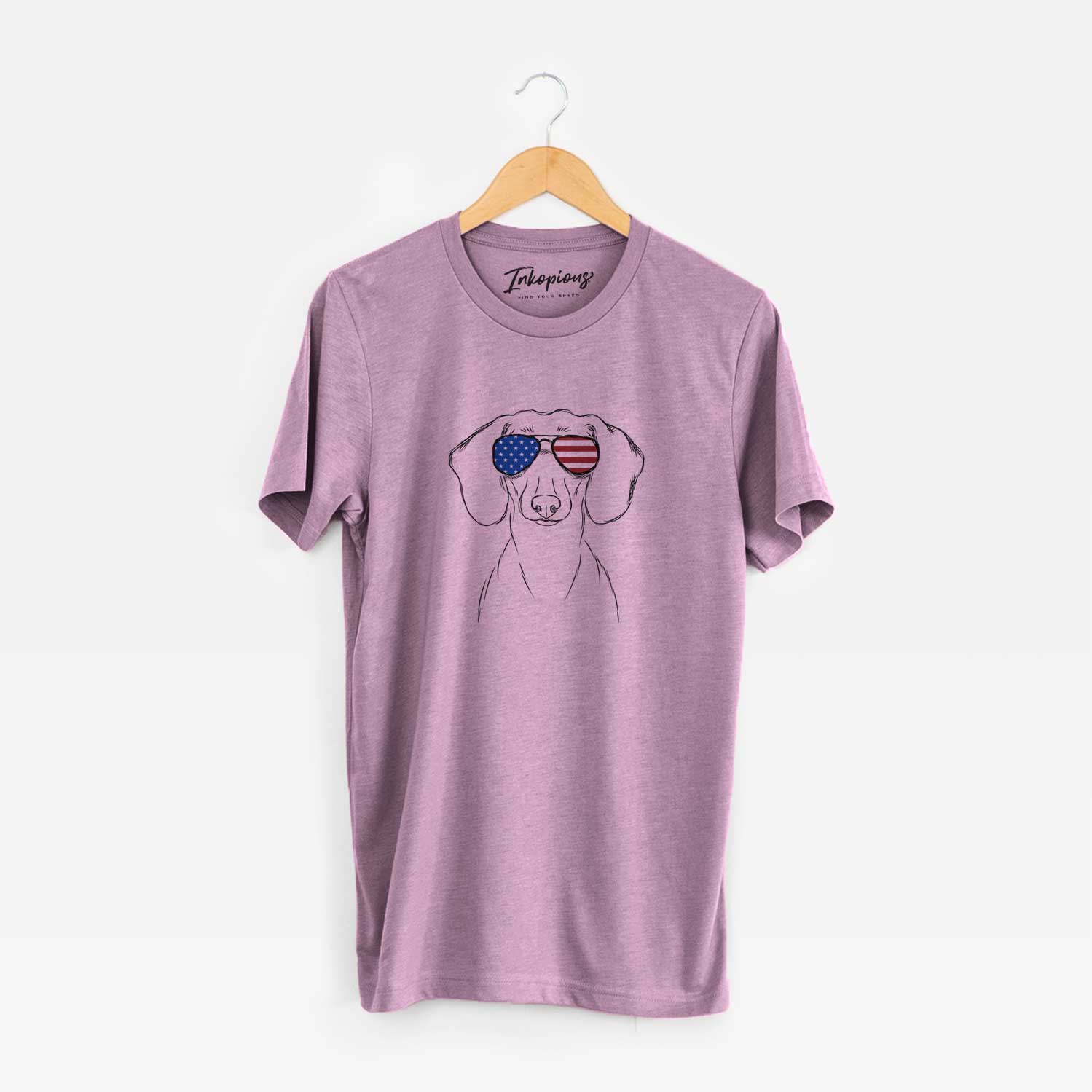 Hand-drawn sketch of Hans the Dachshund wearing American flag sunglasses on an Orchid Unisex crewneck