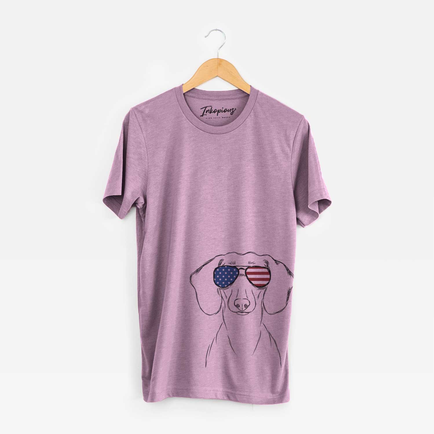 Hand-drawn sketch of Hans the Dachshund wearing American flag sunglasses on an Orchid Unisex crewneck