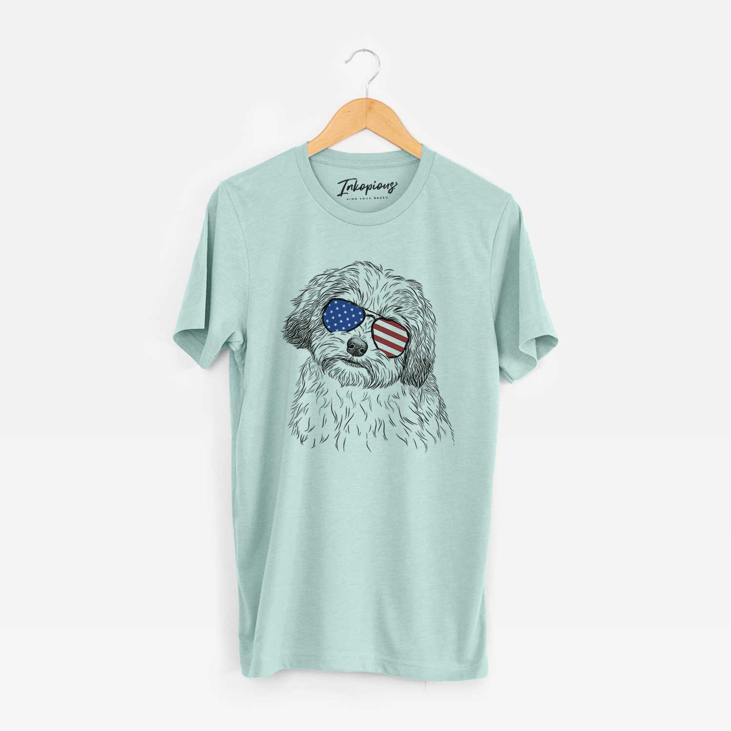Hand-drawn sketch of Henry the Havanese wearing American flag sunglasses on a Heather Sage Unisex crewneck