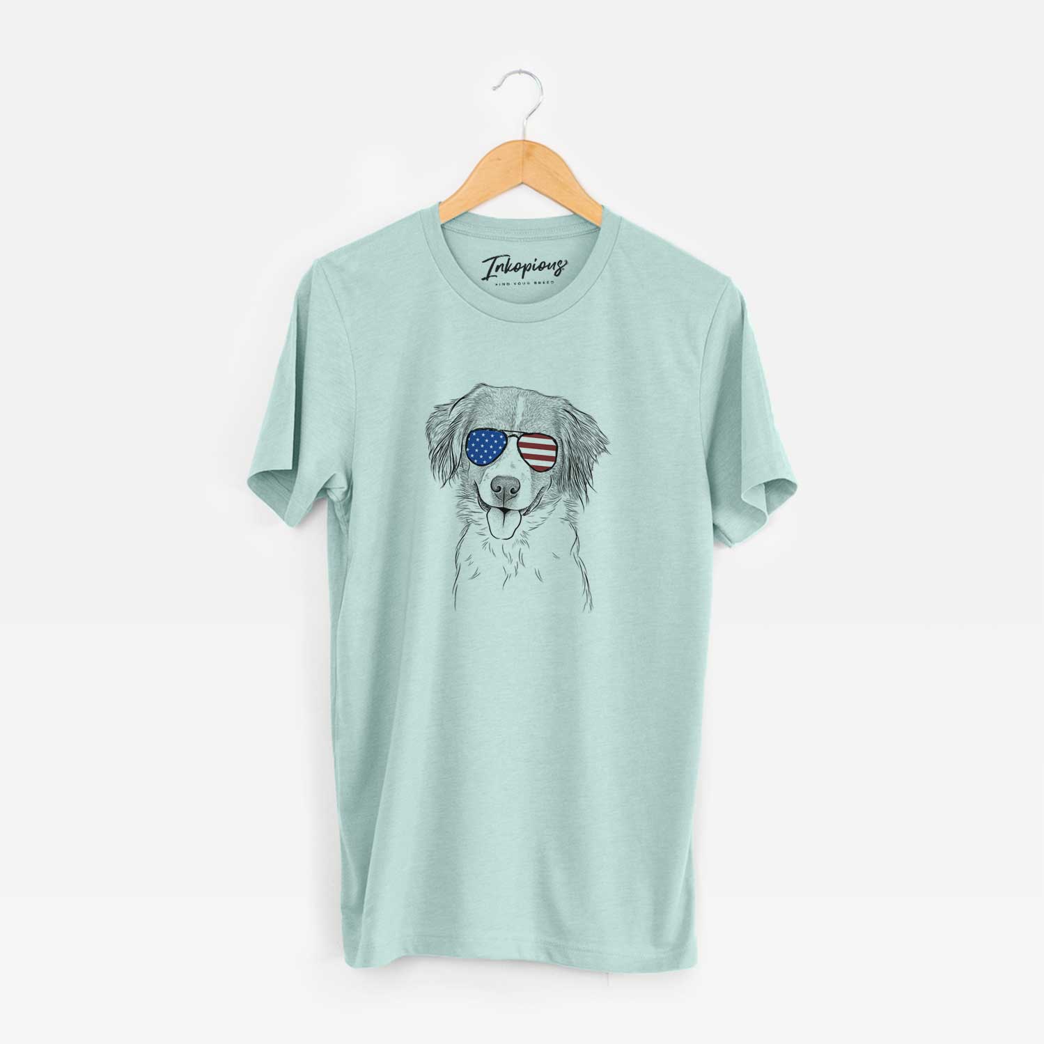 Hand-drawn sketch of Hercules the Nederlandse Kooikerhondje wearing American flag sunglasses on a Heather Sage Unisex crewneck