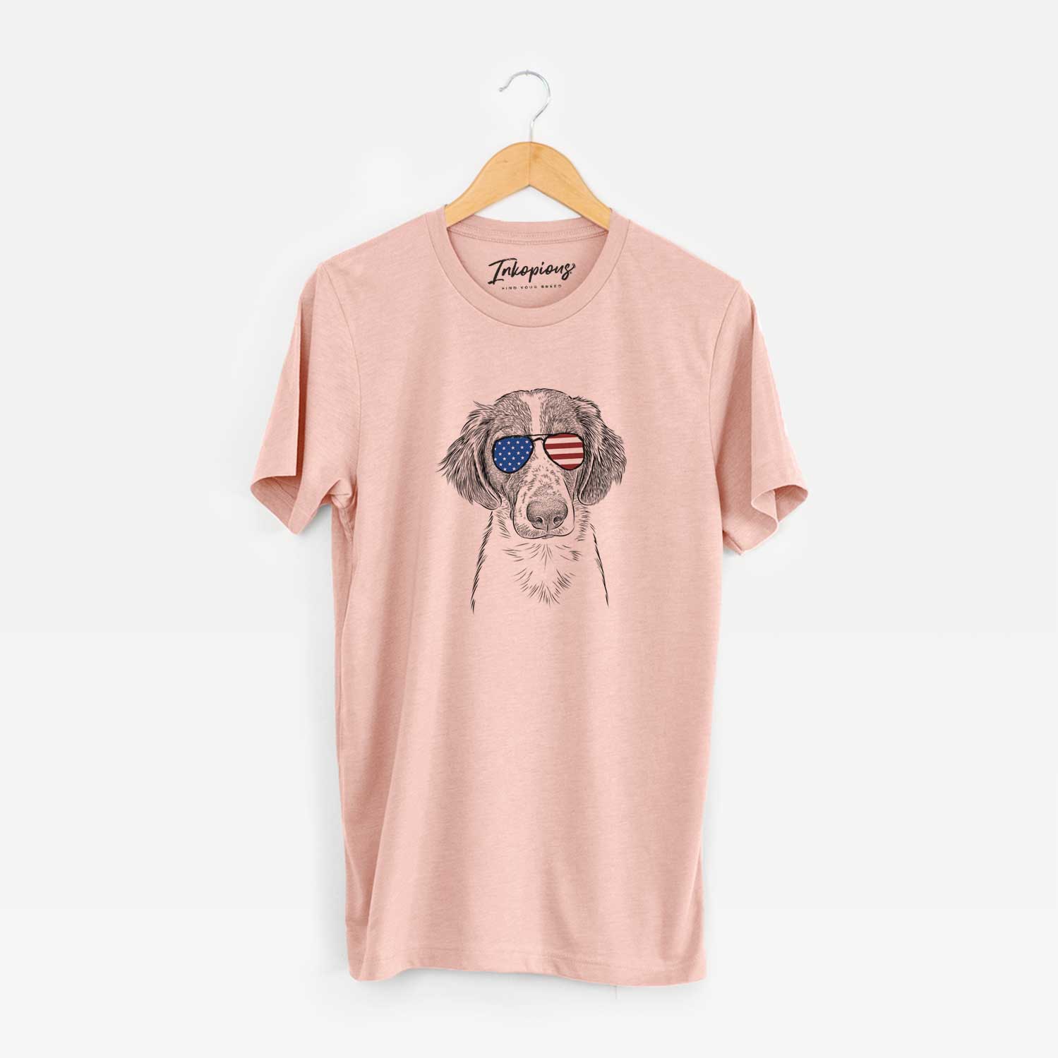 Hand-drawn sketch of Holly the Brittany Spaniel wearing American flag sunglasses on a Peach Unisex crewneck