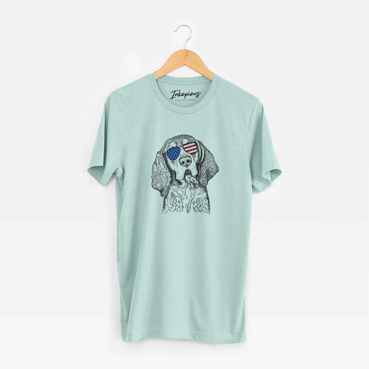Hand-drawn sketch of Huck the Bluetick Coonhound wearing American flag sunglasses on a Heather Sage Unisex crewneck