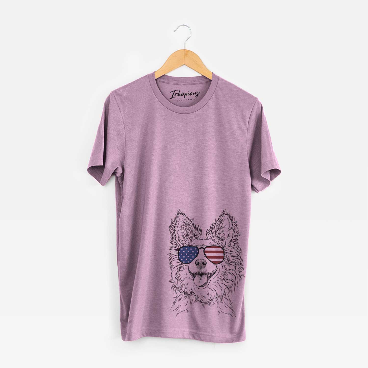 Hand-drawn sketch of Jasper the Pomchi wearing American flag sunglasses on an Orchid Unisex crewneck