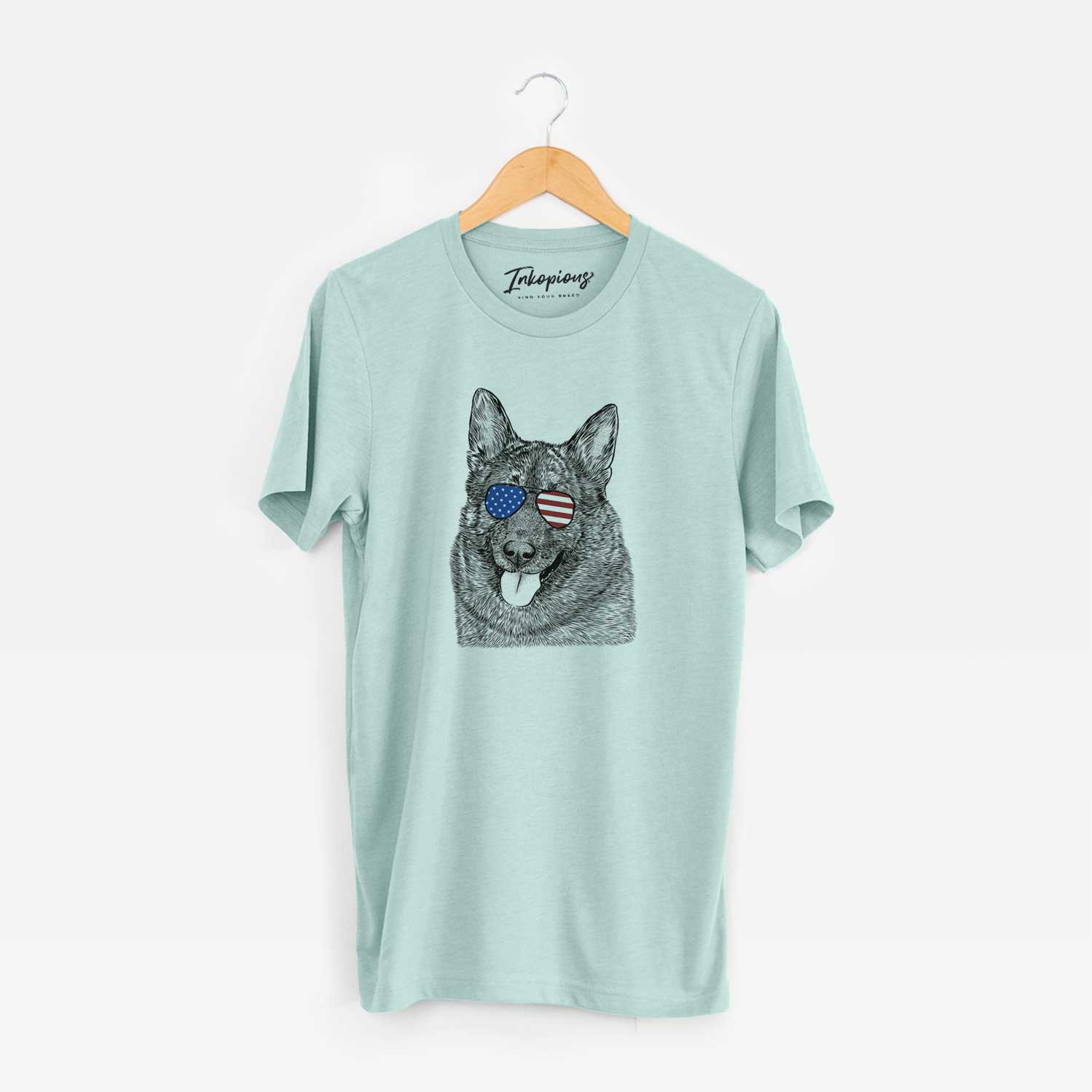 Hand-drawn sketch of Kasia the Norwegian Elkhound wearing American flag sunglasses on a Heather Sage Unisex crewneck