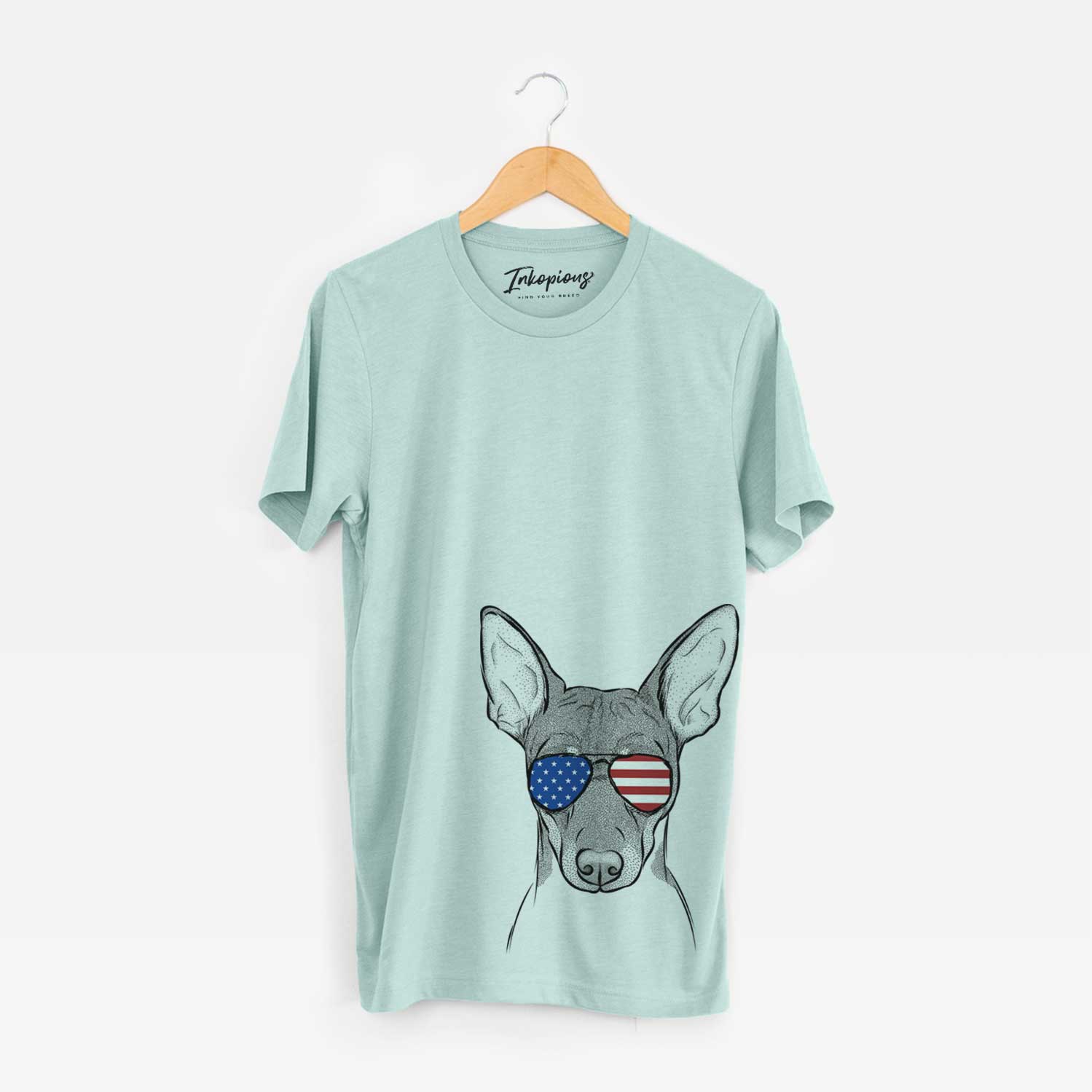 Hand-drawn sketch of Knox the Rat Terrier wearing American flag sunglasses on a Heather Sage Unisex crewneck