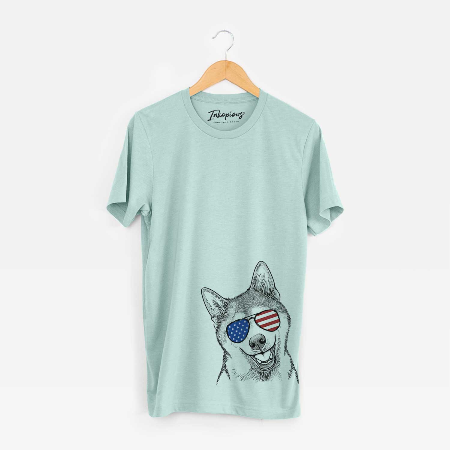 Hand-drawn sketch of Koby the Shiba Inu wearing American flag sunglasses on a Heather Sage Unisex crewneck