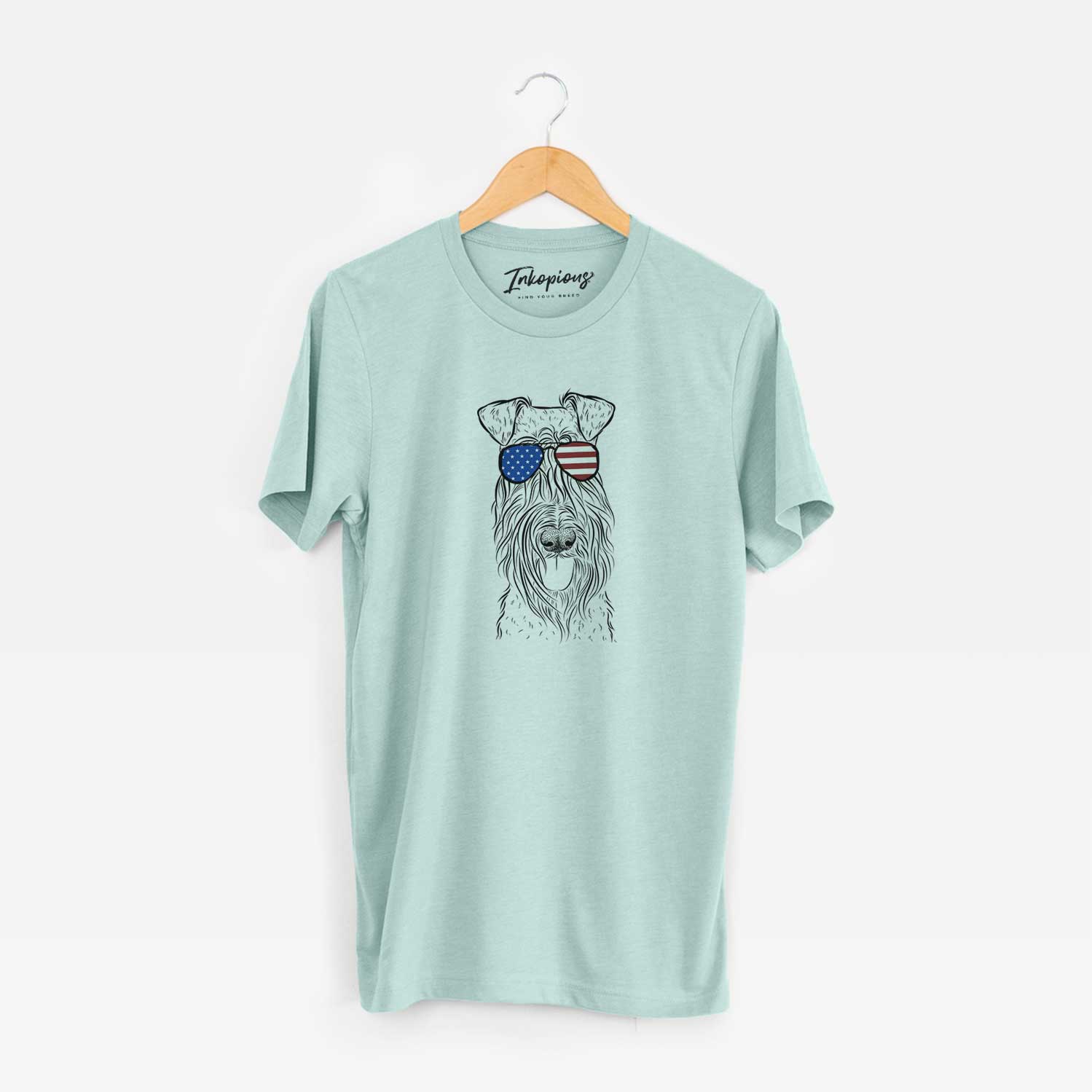 Hand-drawn sketch of Kricket the Kerry Blue Terrier wearing American flag sunglasses on a Heather Sage Unisex crewneck