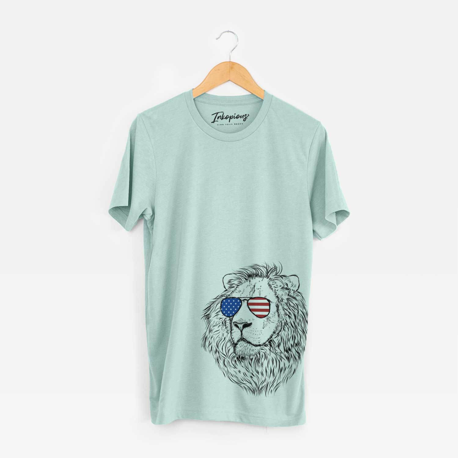 Hand-drawn sketch of Lenny the Lion wearing American flag sunglasses on a Heather Sage Unisex crewneck