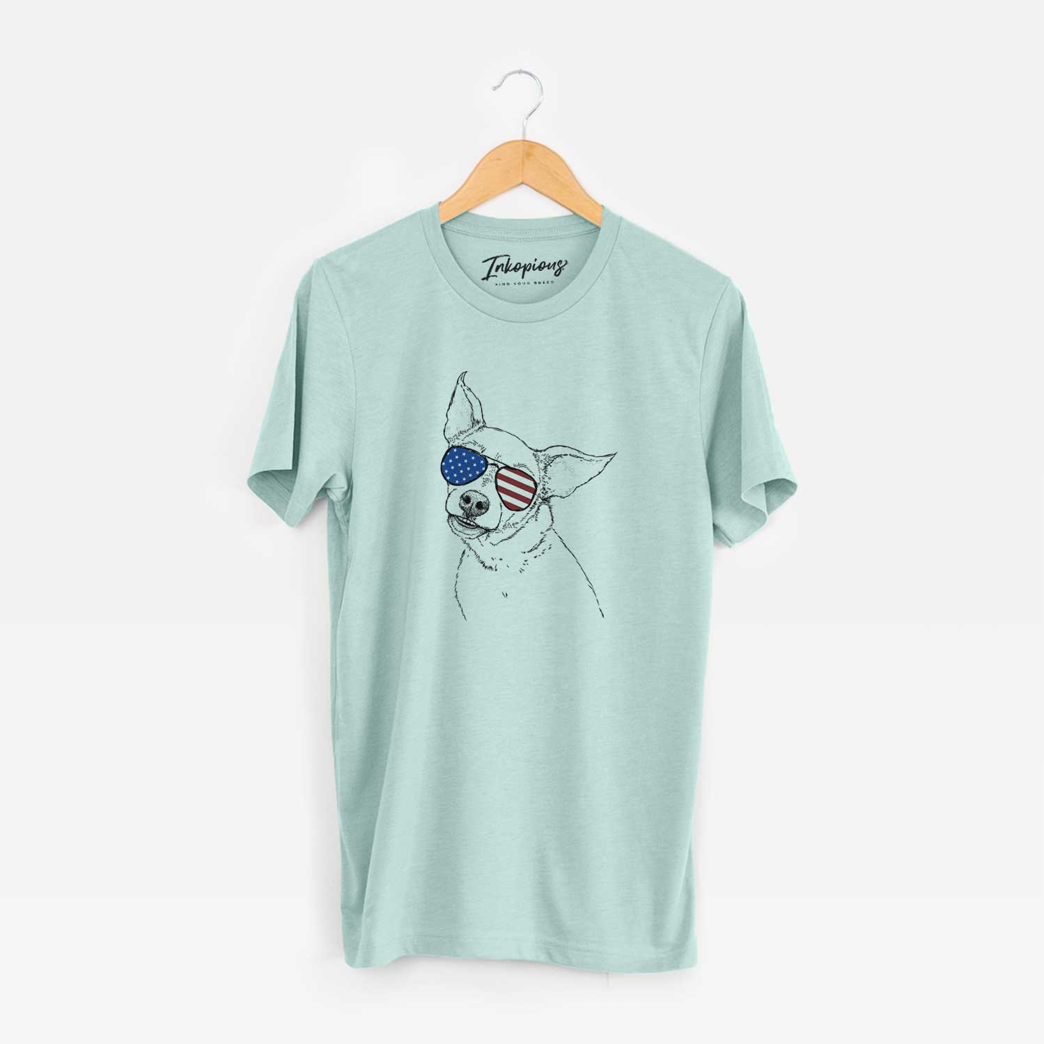 Hand-drawn sketch of Lola the Chiweenie wearing American flag sunglasses on a Heather Sage Unisex crewneck