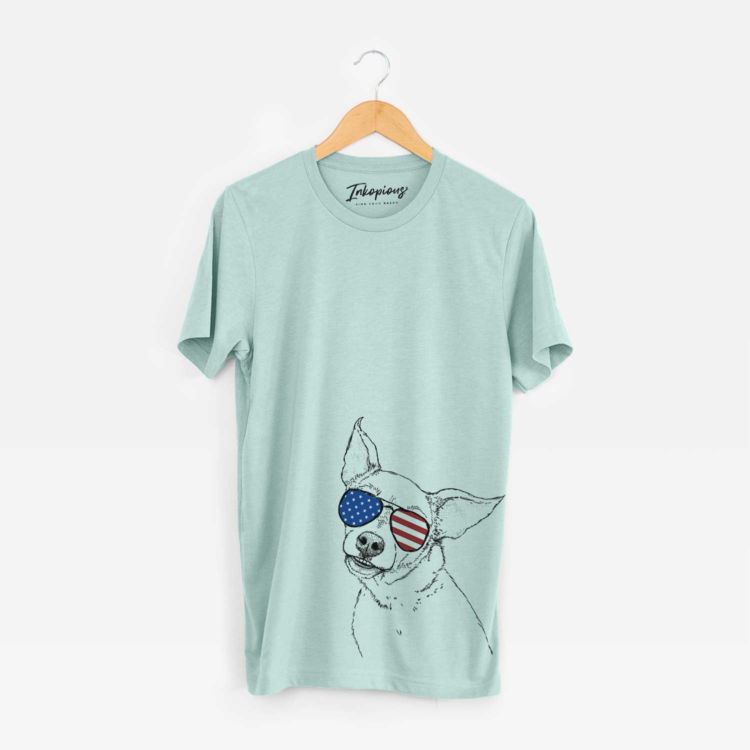 Hand-drawn sketch of Lola the Chiweenie wearing American flag sunglasses on a Heather Sage Unisex crewneck