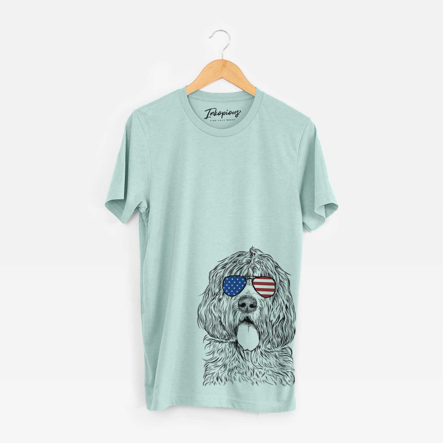 Hand-drawn sketch of Lou the Otterhound wearing American flag sunglasses on a Heather Sage Unisex crewneck
