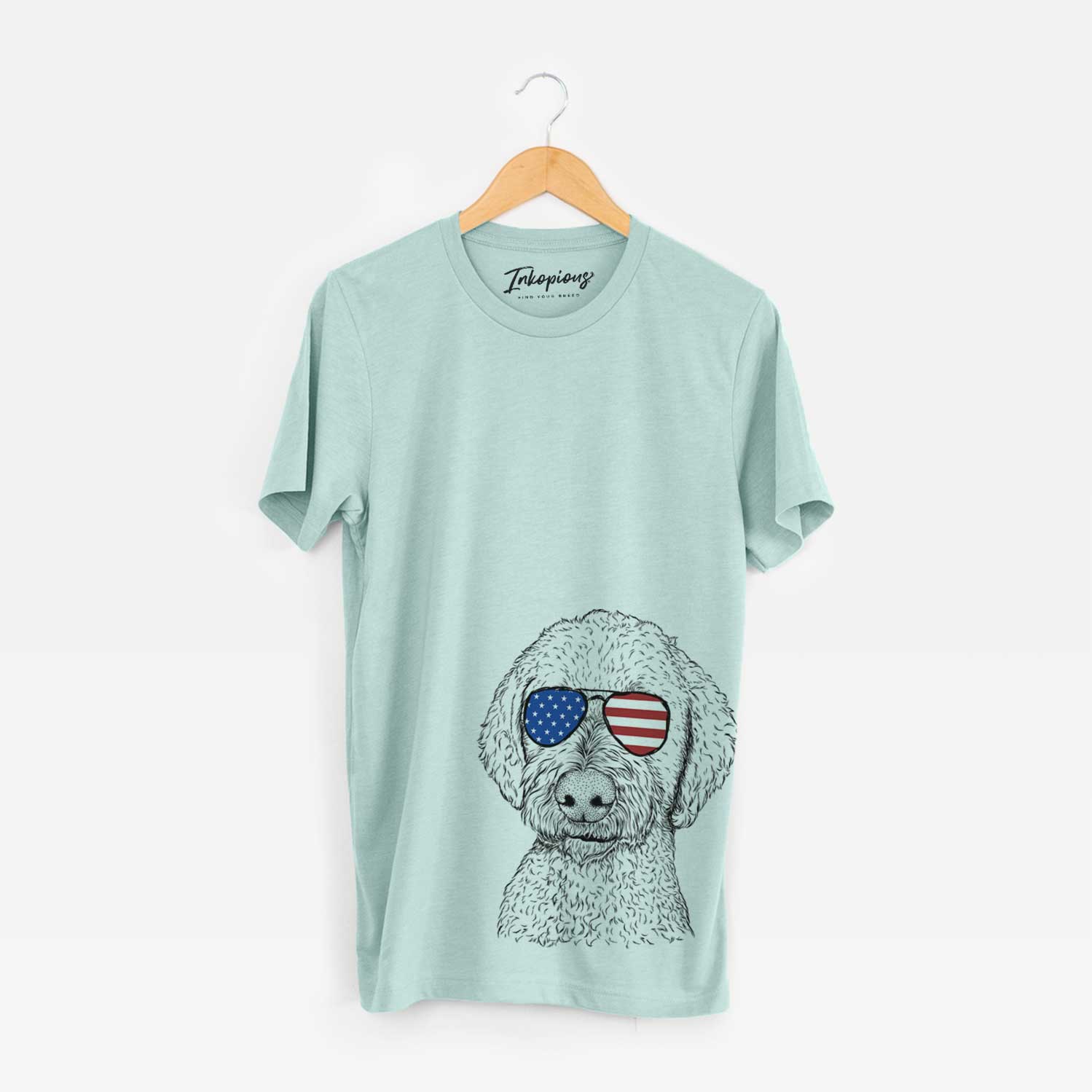Hand-drawn sketch of Lucy Boo the Goldendoodle wearing American flag sunglasses on a Heather Sage Unisex crewneck