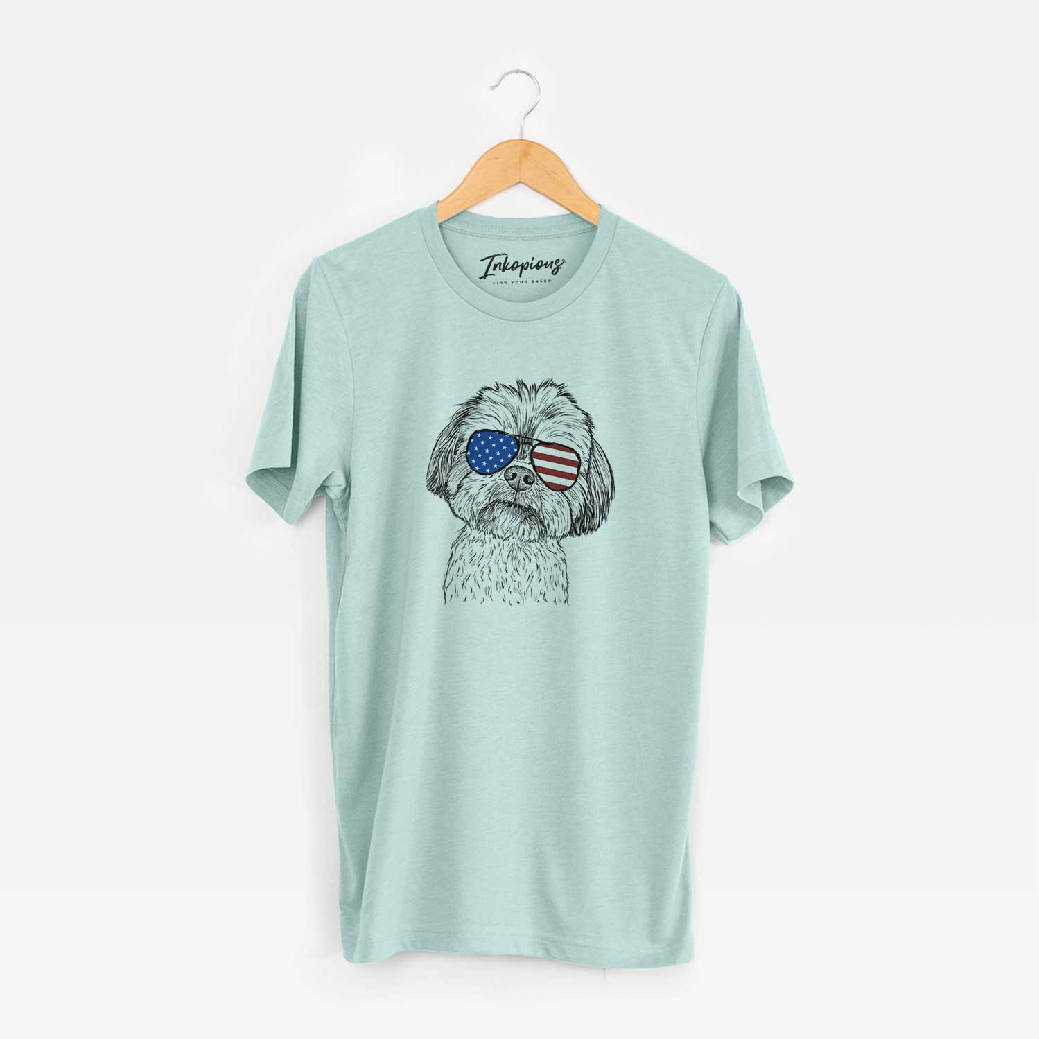 Hand-drawn sketch of Lucy the Shorkie wearing American flag sunglasses on a Heather Sage Unisex crewneck