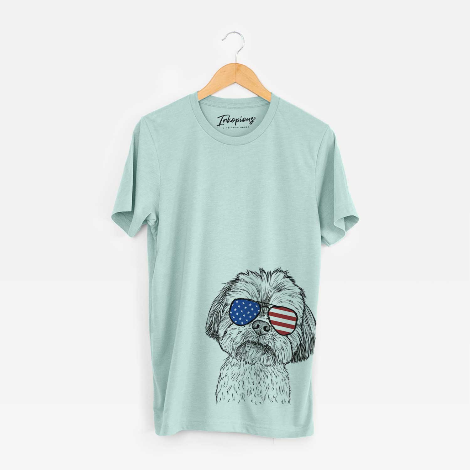 Hand-drawn sketch of Lucy the Shorkie wearing American flag sunglasses on a Heather Sage Unisex crewneck