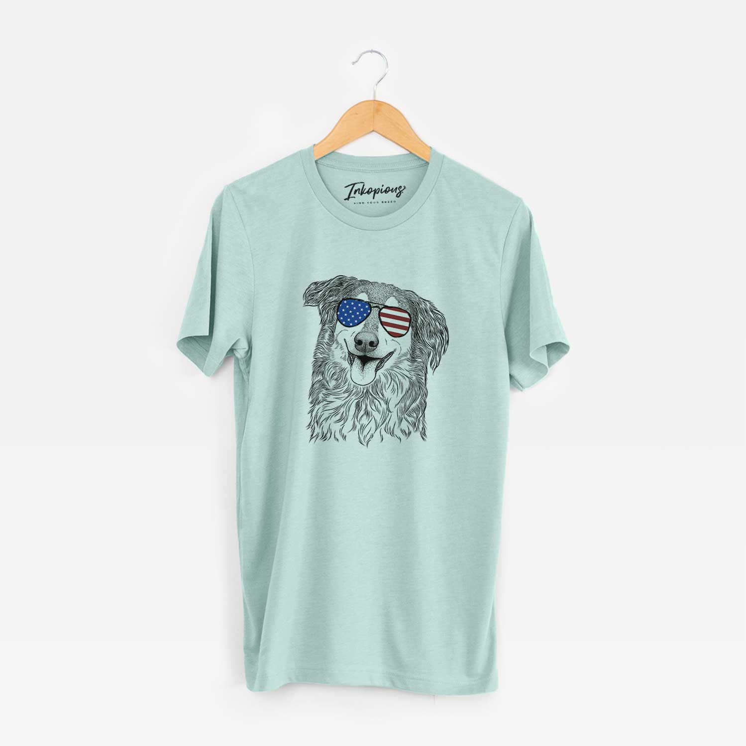 Hand-drawn sketch of Maddie the English Shepherd wearing American flag sunglasses on a Heather Sage Unisex crewneck