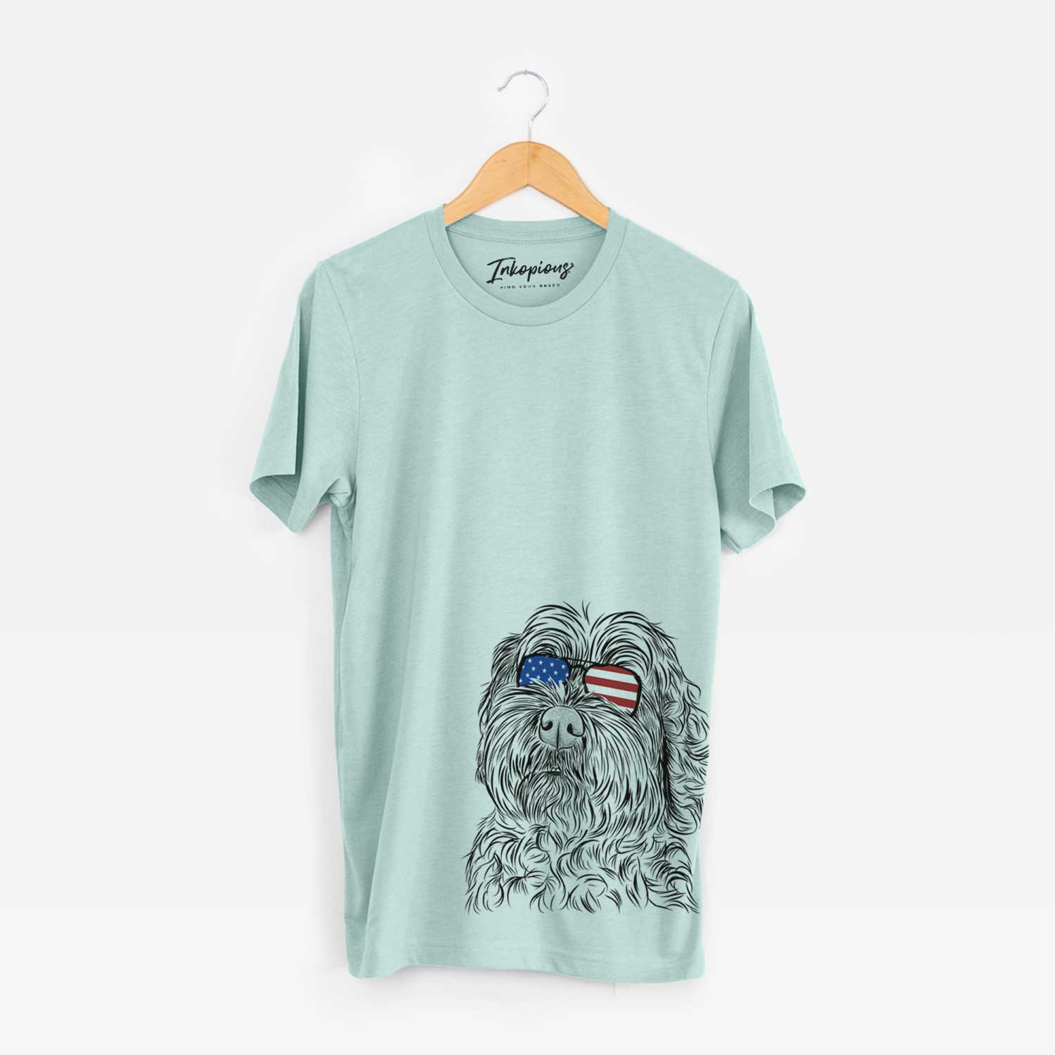 Hand-drawn sketch of Maggie Girl the Cockapoo wearing American flag sunglasses on a Heather Sage Unisex crewneck