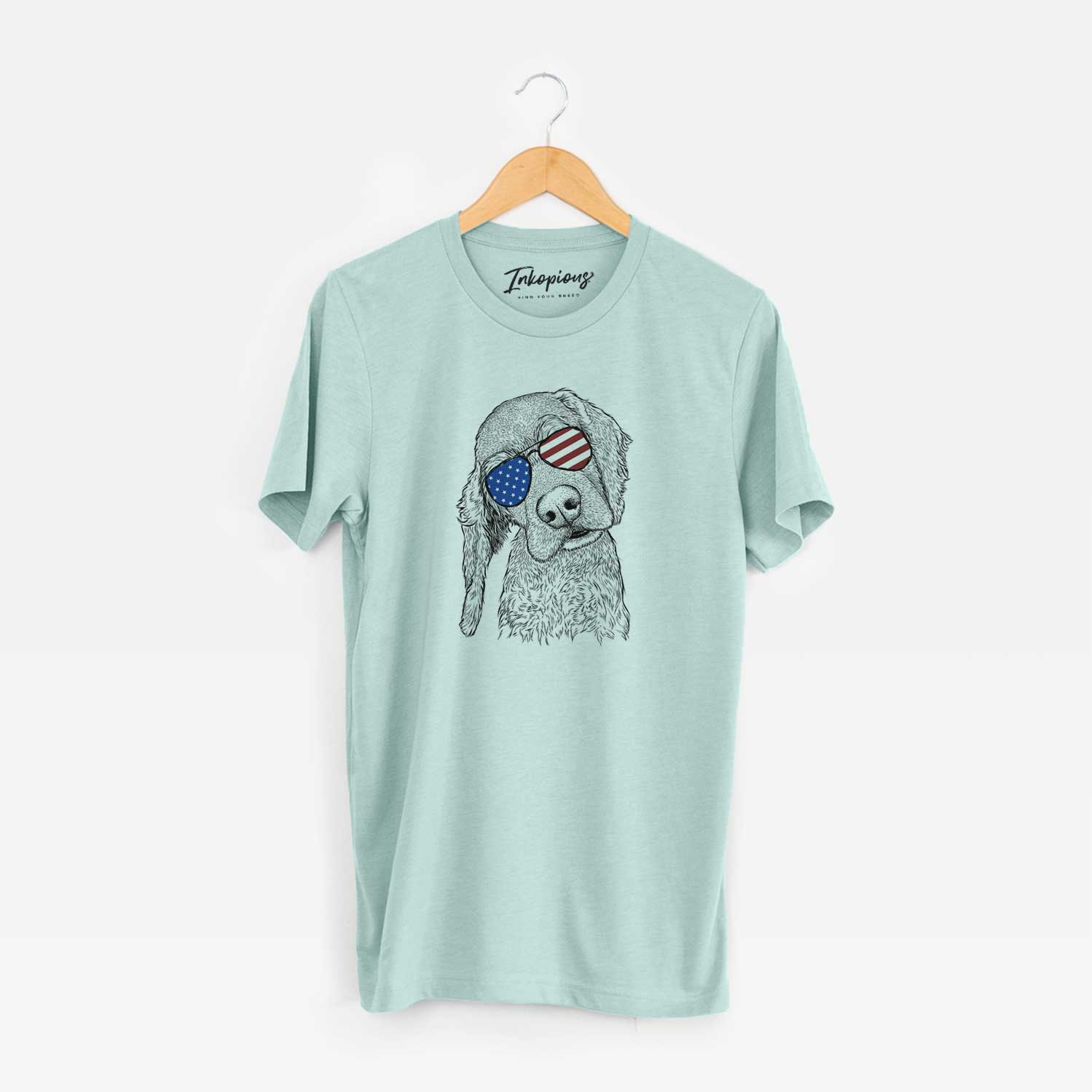 Hand-drawn sketch of Mambo #5 the Cocker Spaniel wearing American flag sunglasses on a Heather Sage Unisex crewneck