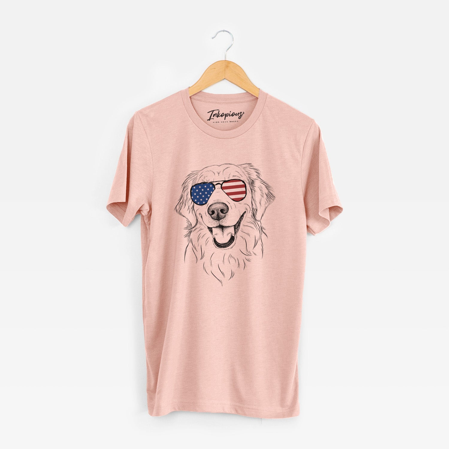 Hand-drawn sketch of Maple the Golden Retriever wearing American flag sunglasses on a Peach Unisex crewneck