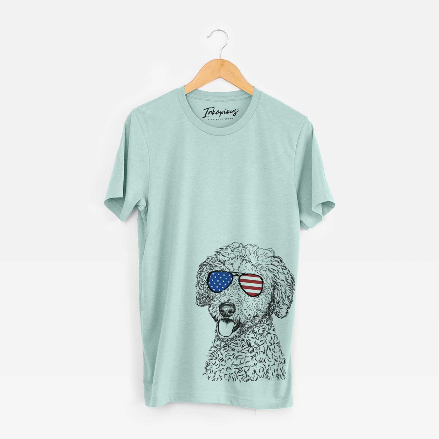 Hand-drawn sketch of Marlow the Goldendoodle wearing American flag sunglasses on a Heather Sage Unisex crewneck