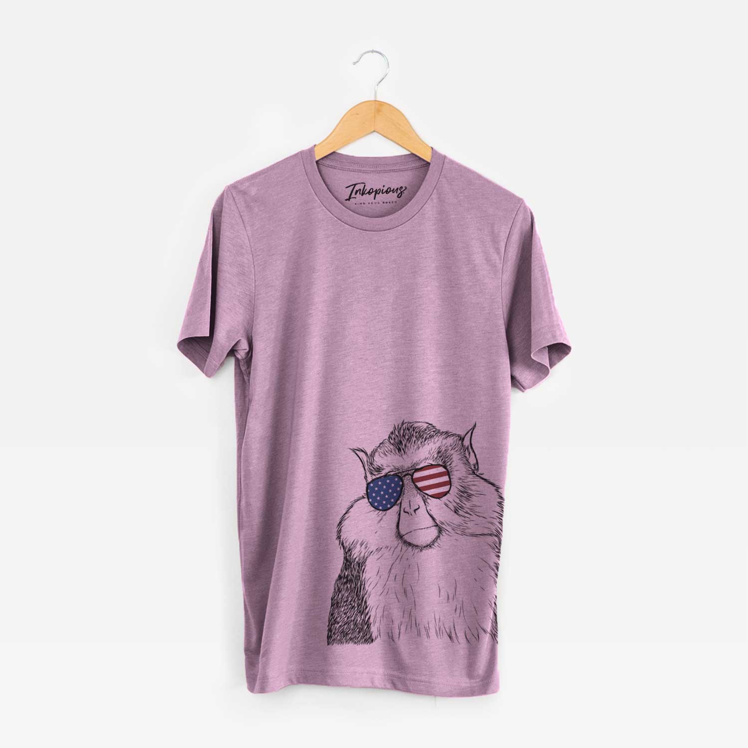 Hand-drawn sketch of Matata the Mona Monkey wearing American flag sunglasses on an Orchid Unisex crewneck