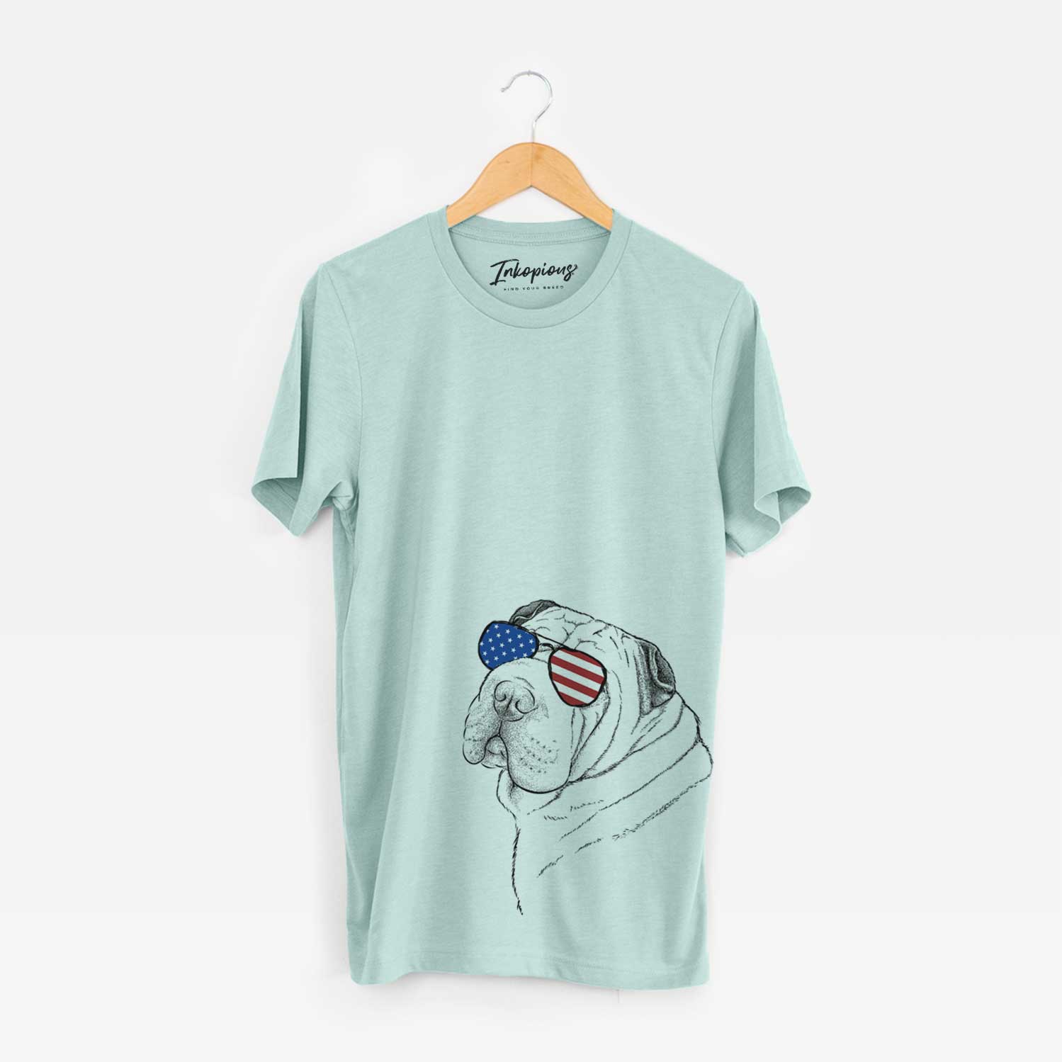 Hand-drawn sketch of Maximus the Shar Pei wearing American flag sunglasses on a Heather Sage Unisex crewneck