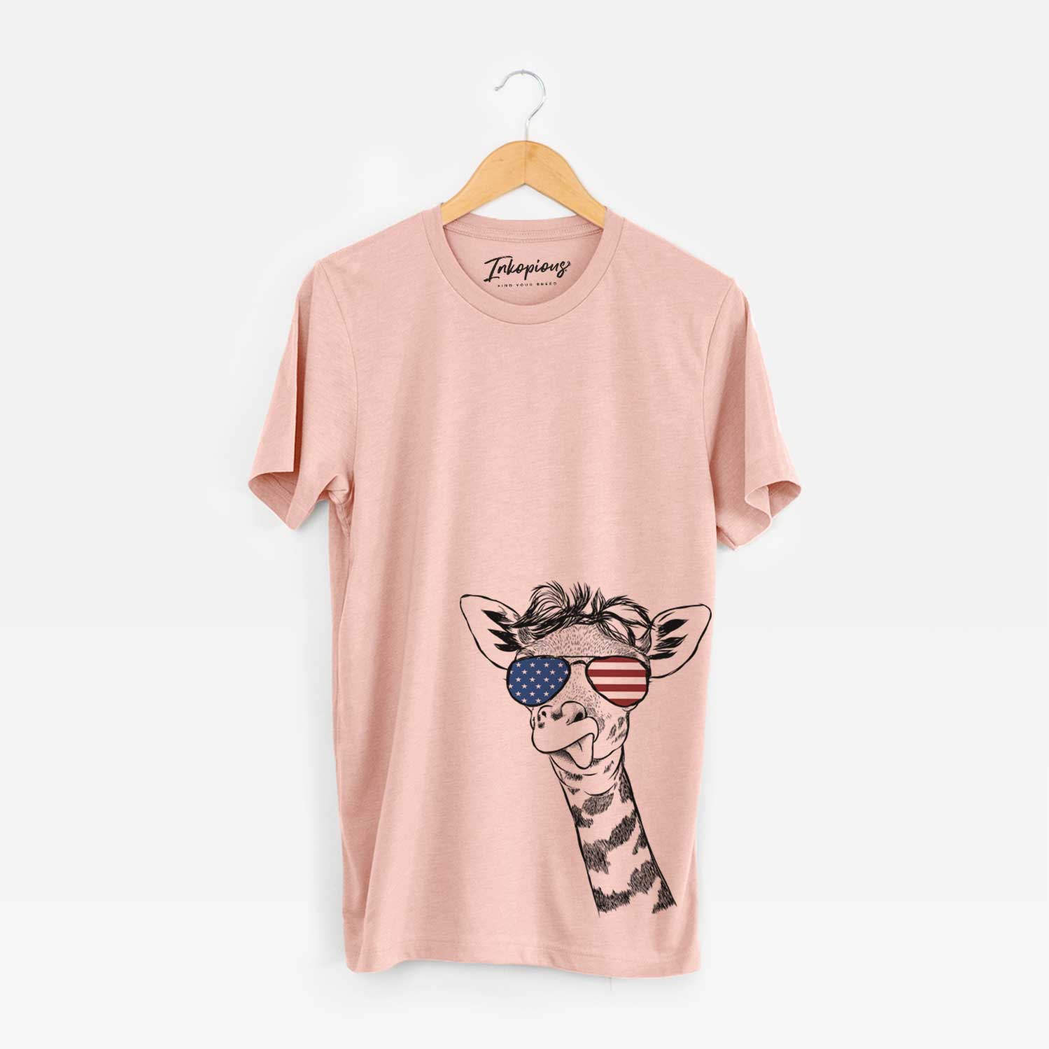 Hand-drawn sketch of Mel the Baby Giraffe wearing American flag sunglasses on a Peach Unisex crewneck