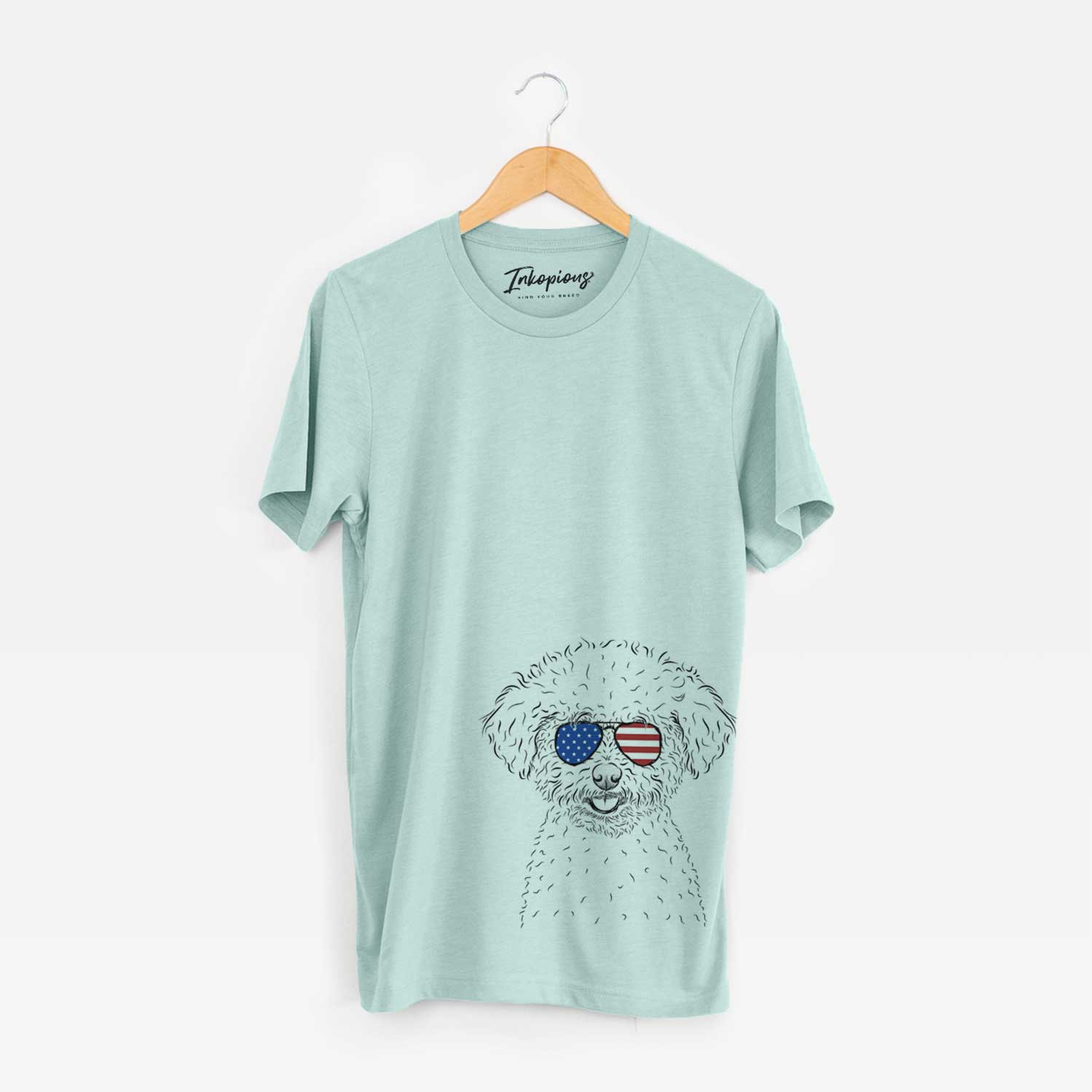 Hand-drawn sketch of Mickey the Bichon Frise wearing American flag sunglasses on a Heather Sage Unisex crewneck