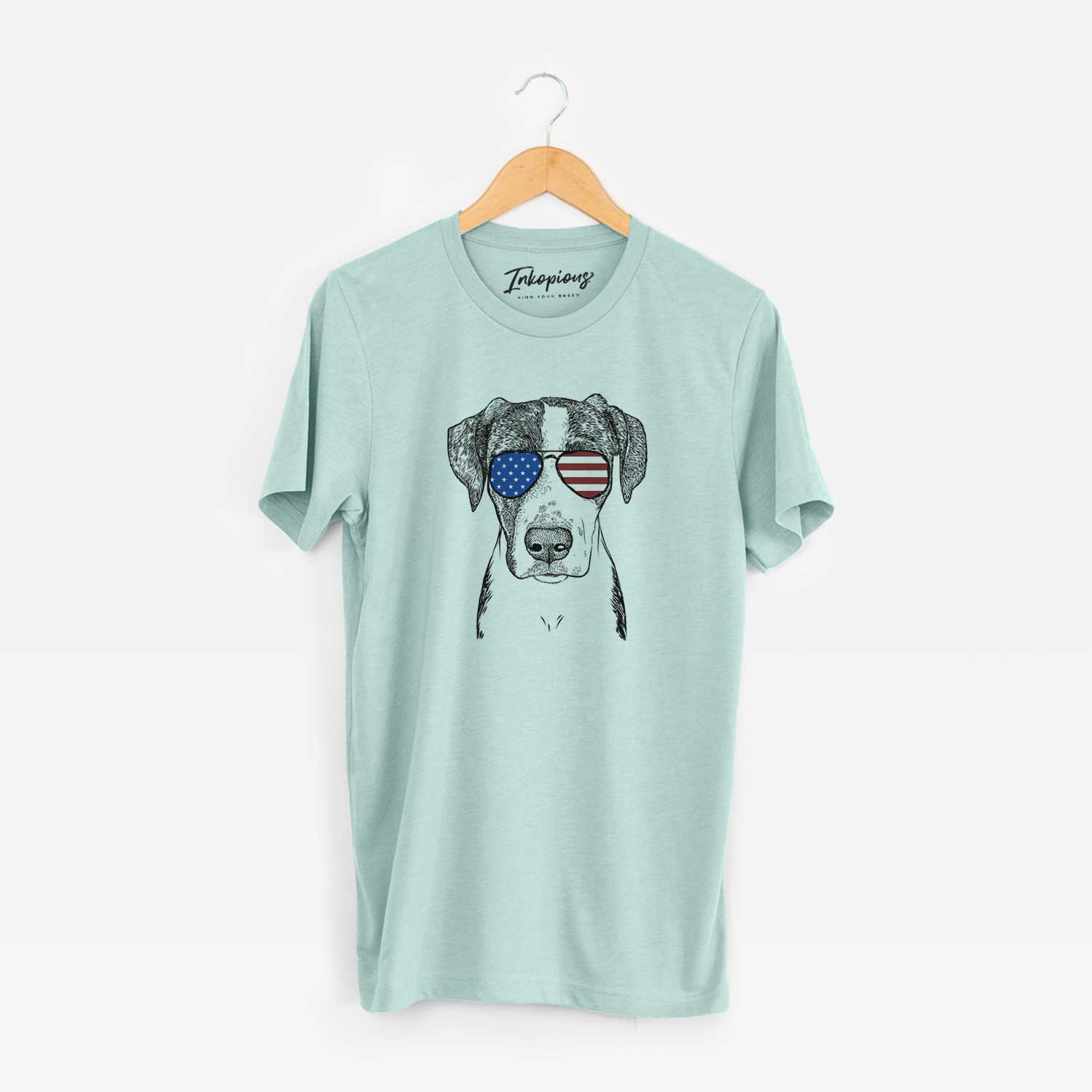Hand-drawn sketch of Milo the Mixed Breed wearing American flag sunglasses on a Heather Sage Unisex crewneck