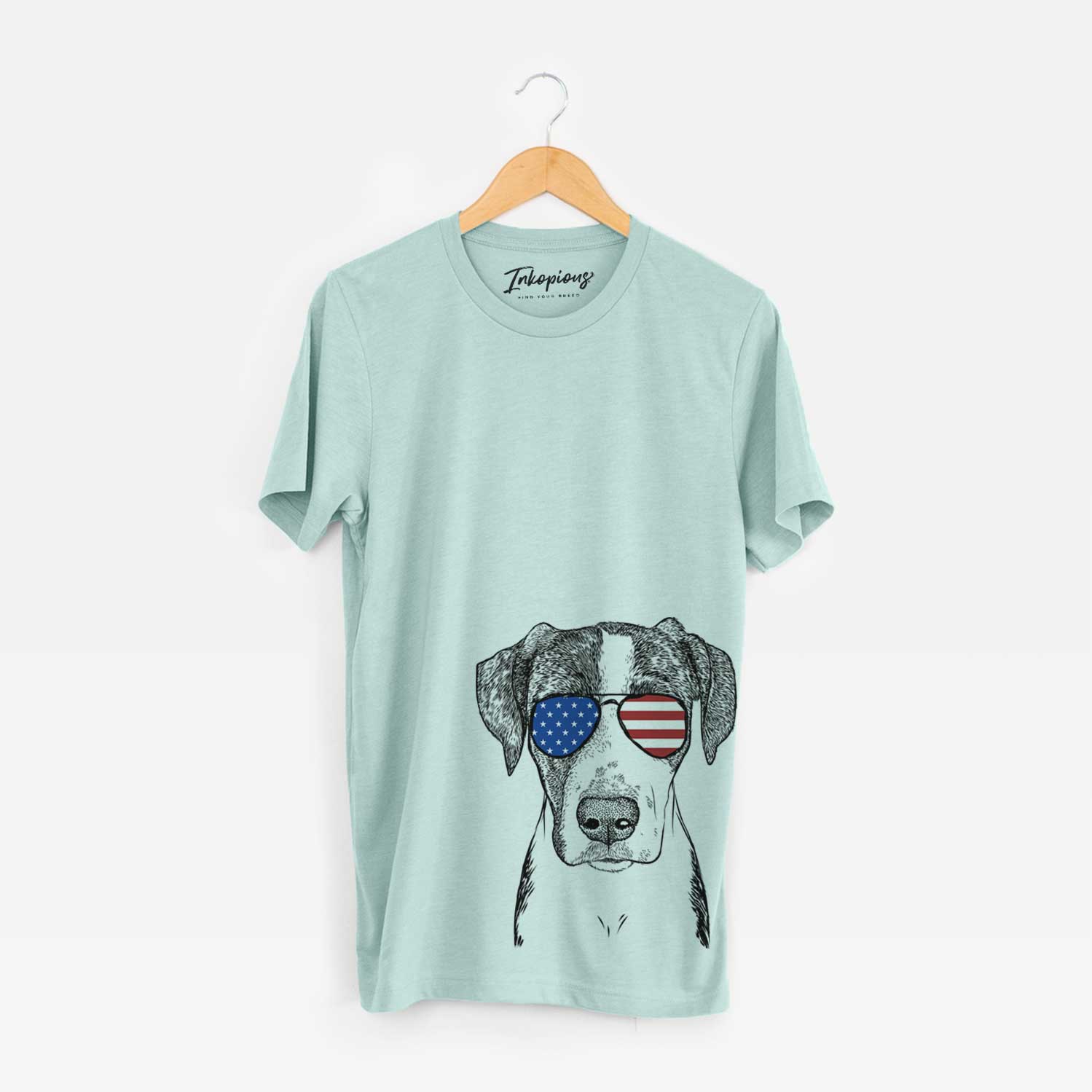 Hand-drawn sketch of Milo the Mixed Breed wearing American flag sunglasses on a Heather Sage Unisex crewneck
